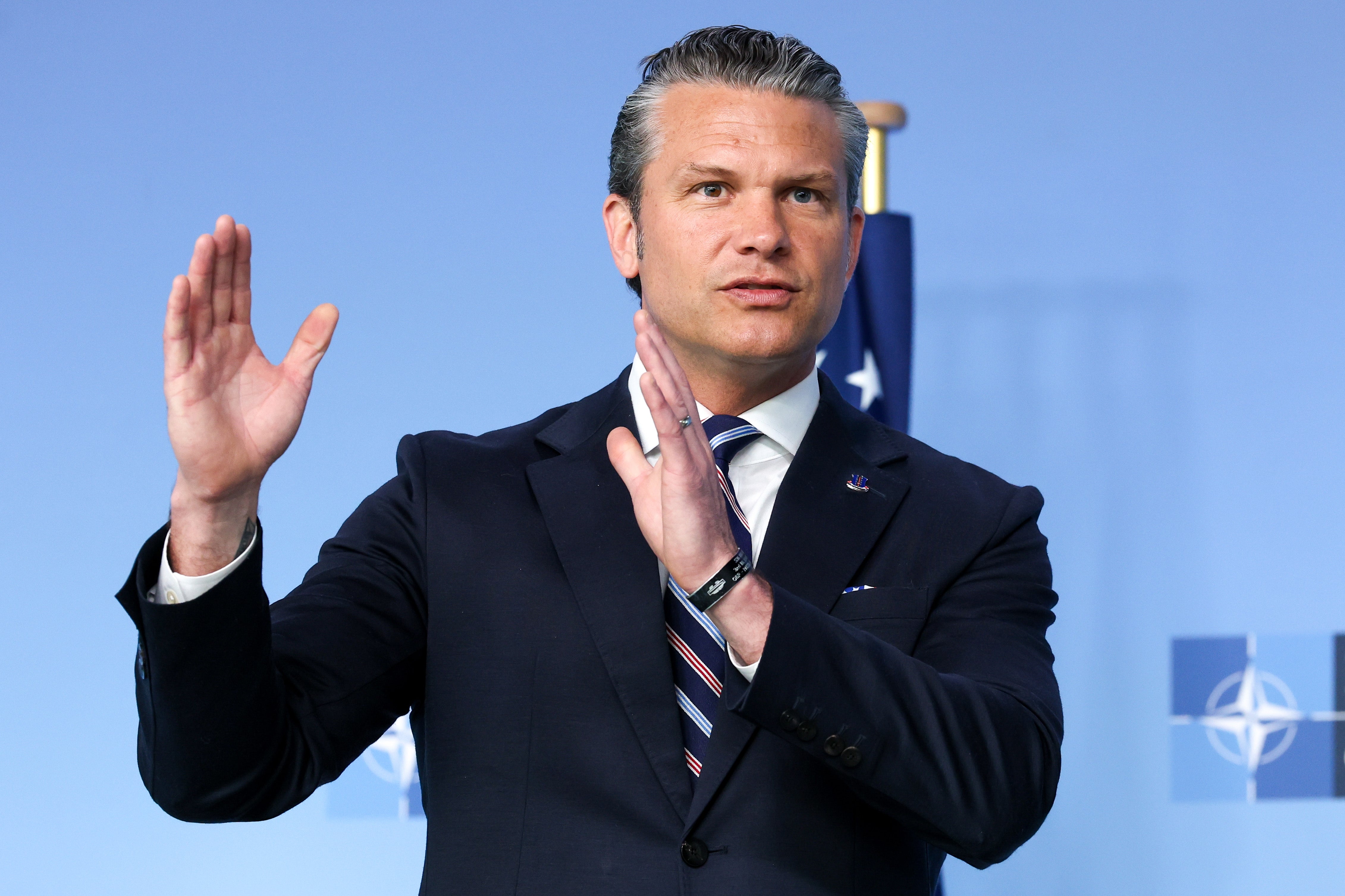 A antheral   successful  a suit   gestures portion    speaking astatine  a NATO event, against a backdrop with NATO logos