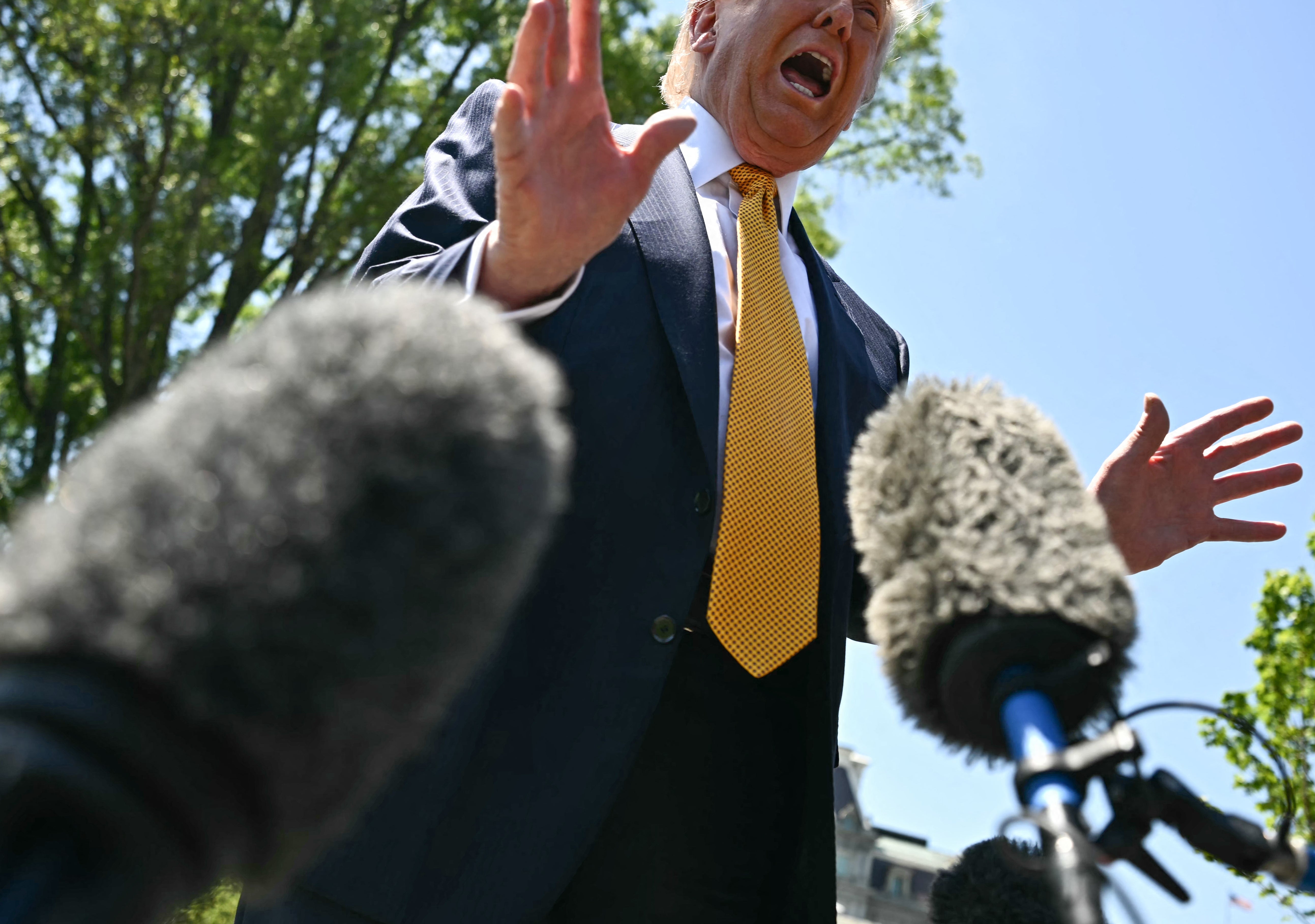 Person speaking passionately to microphones outdoors