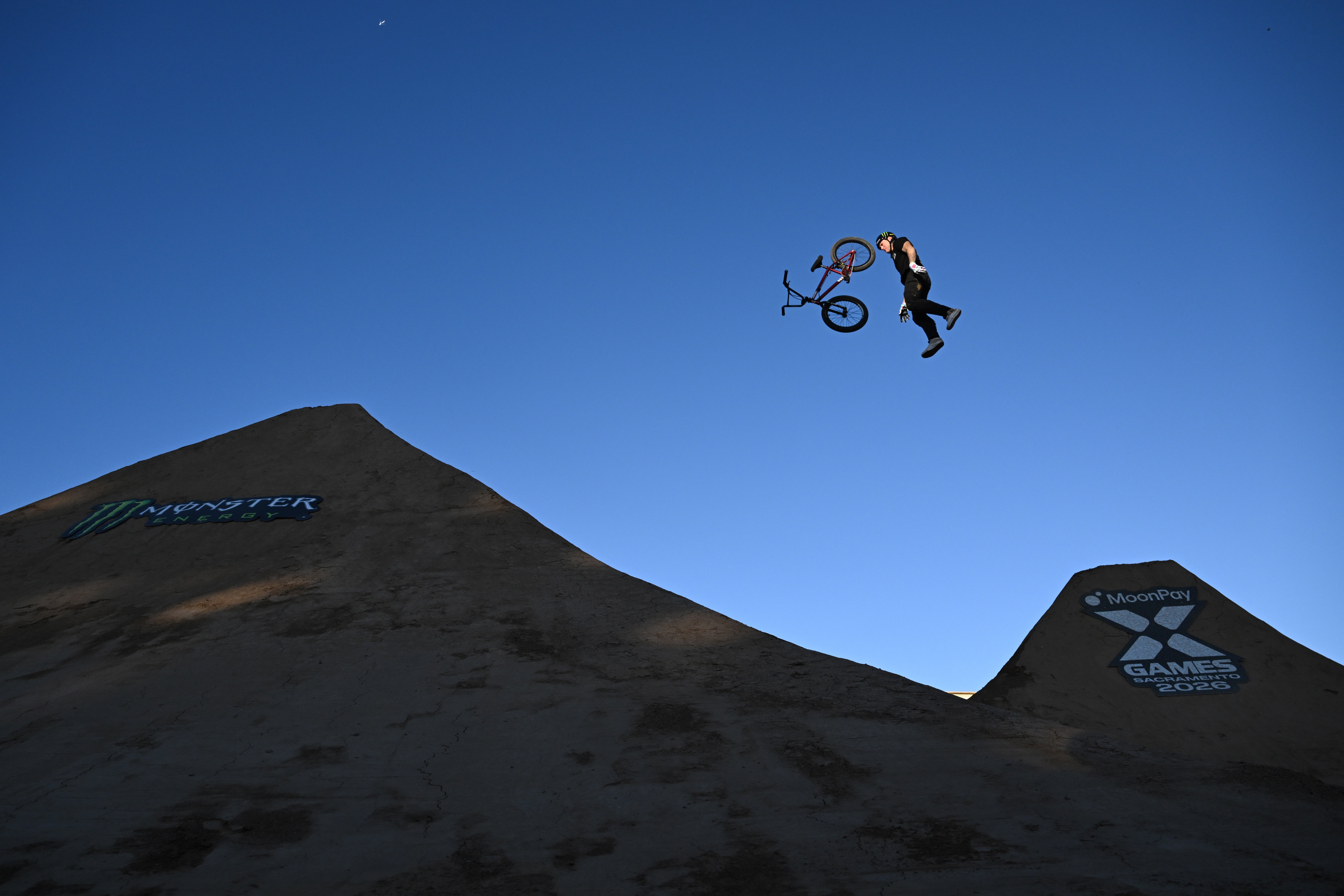 A cyclist performs an aerial stunt, leaping disconnected  their BMX motorcycle  mid-air connected  a ample  ungraded  ramp astatine  the X Games course