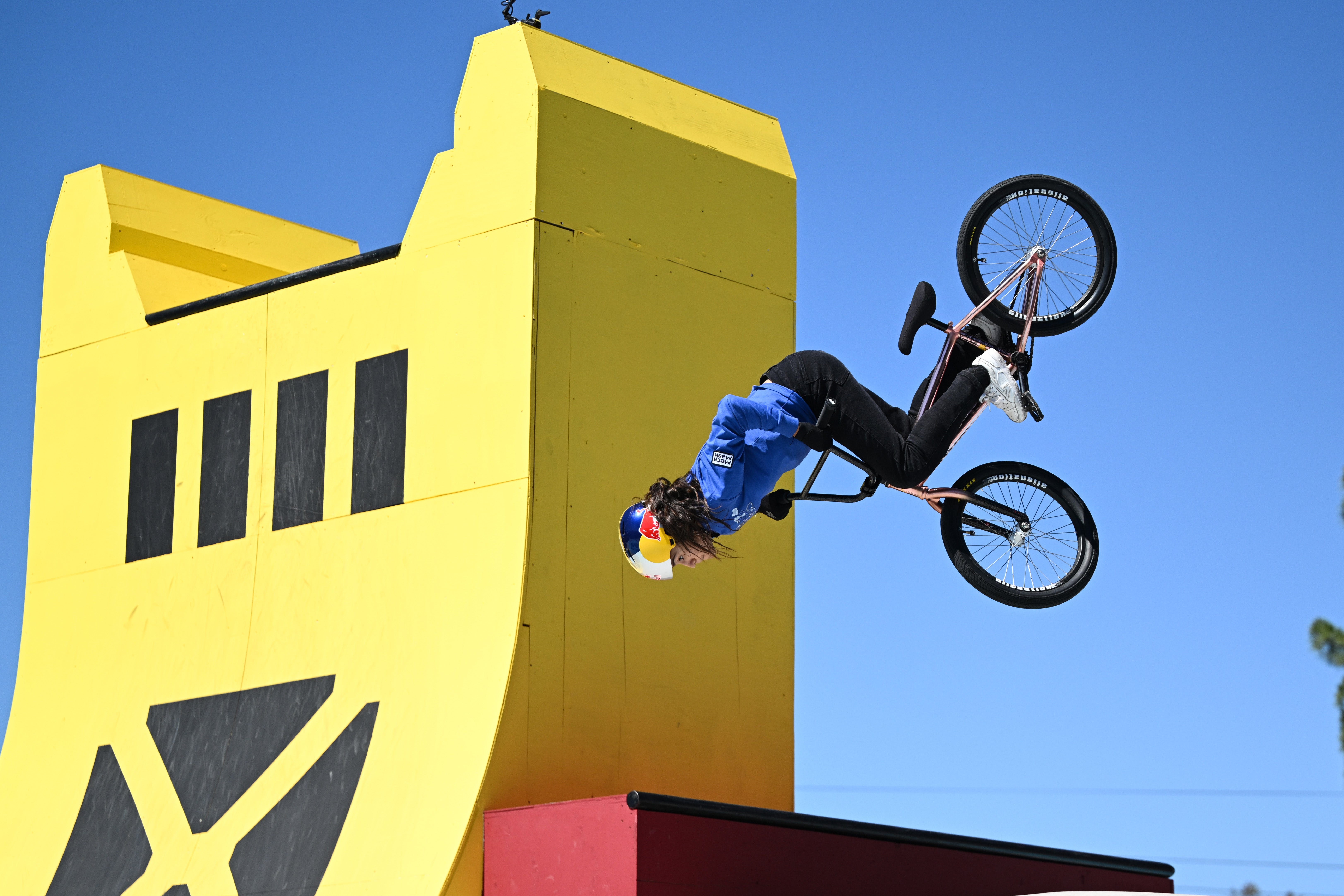 Person performs a BMX backflip disconnected  a ramp against a agleam  sky, showcasing awesome  motorcycle  skills
