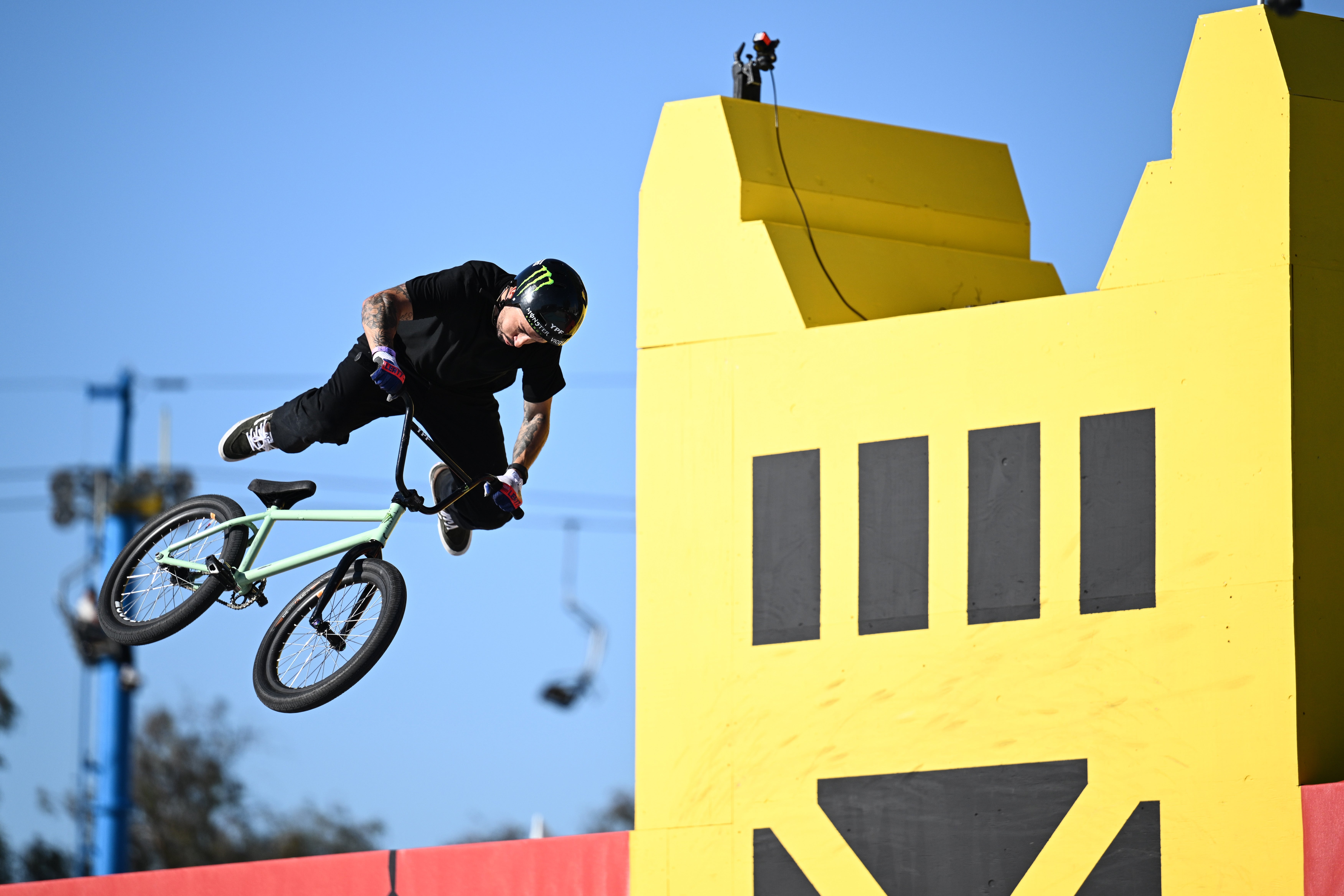 A BMX rider performs an aerial instrumentality   successful  beforehand   of a ample  yellowish  operation   during an outdoor event