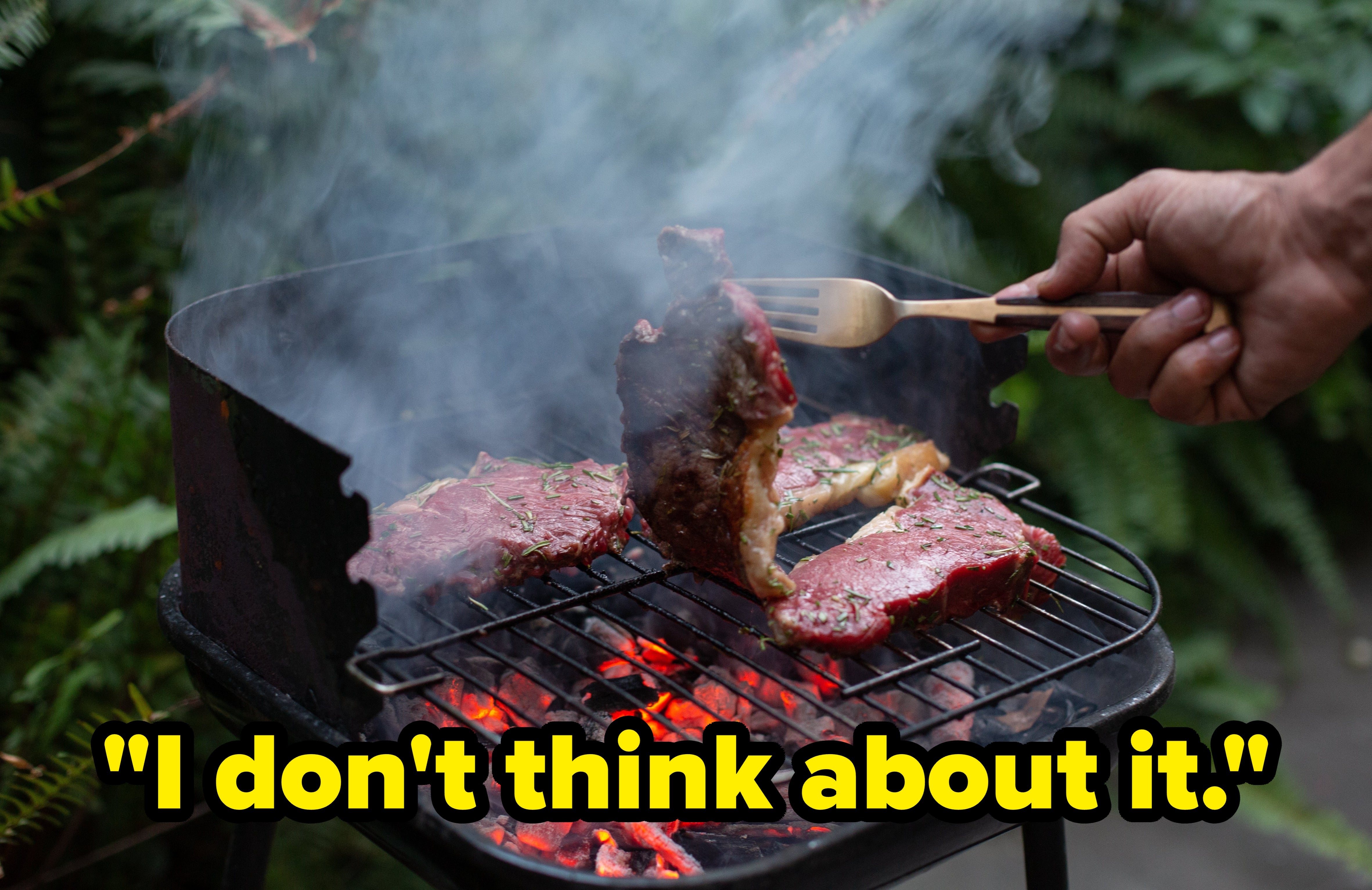 Person grilling steaks implicit blistery coals connected a barbecue grill, with fume rising