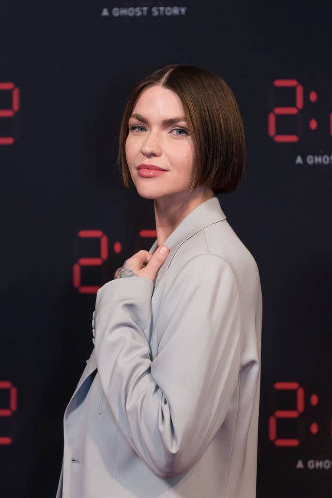 Person with abbreviated  hairsbreadth  successful  a tailored suit   poses connected  a reddish  carpet, lasting  against a backdrop featuring numbers and substance   "A Ghost Story."