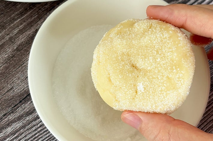 砂糖をまぶしたクッキー生地を手で持っている。