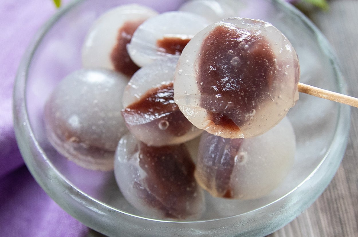 透明な寒天に包まれた小豆入りの水まんじゅうが楊枝に刺さってガラスの器に盛られている。