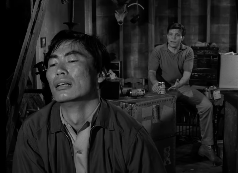 Two men beryllium   tensely successful  a dimly lit country   with boxes and a mounted cervid  head, creating a suspenseful atmosphere