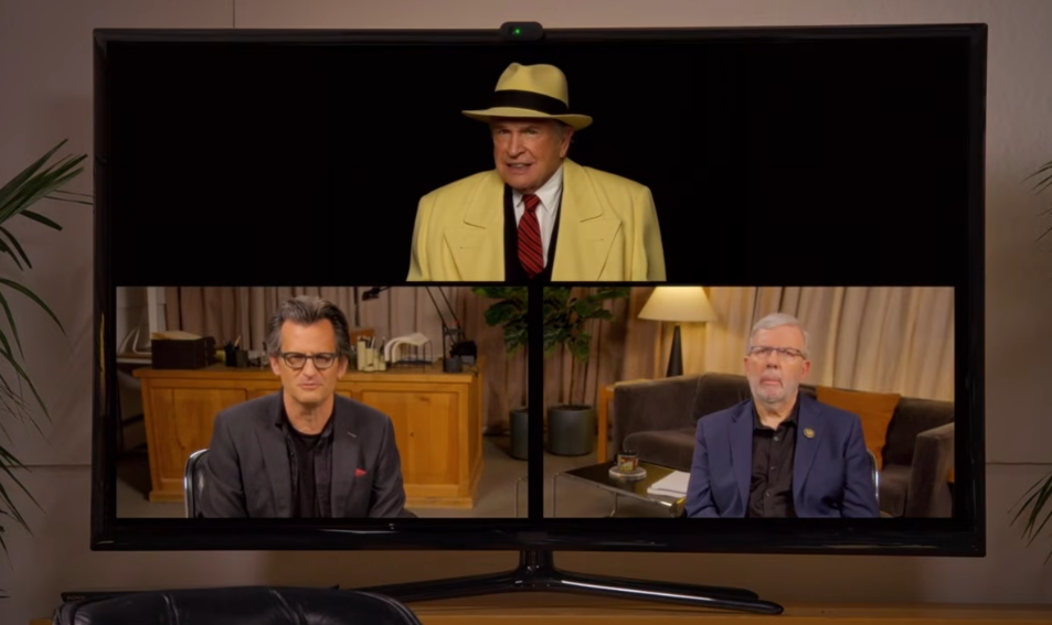 Three radical   successful  a video telephone  connected  a screen, 2  seated successful  offices, 1  wearing a suit   and fedora, styled similar  a classical  film
