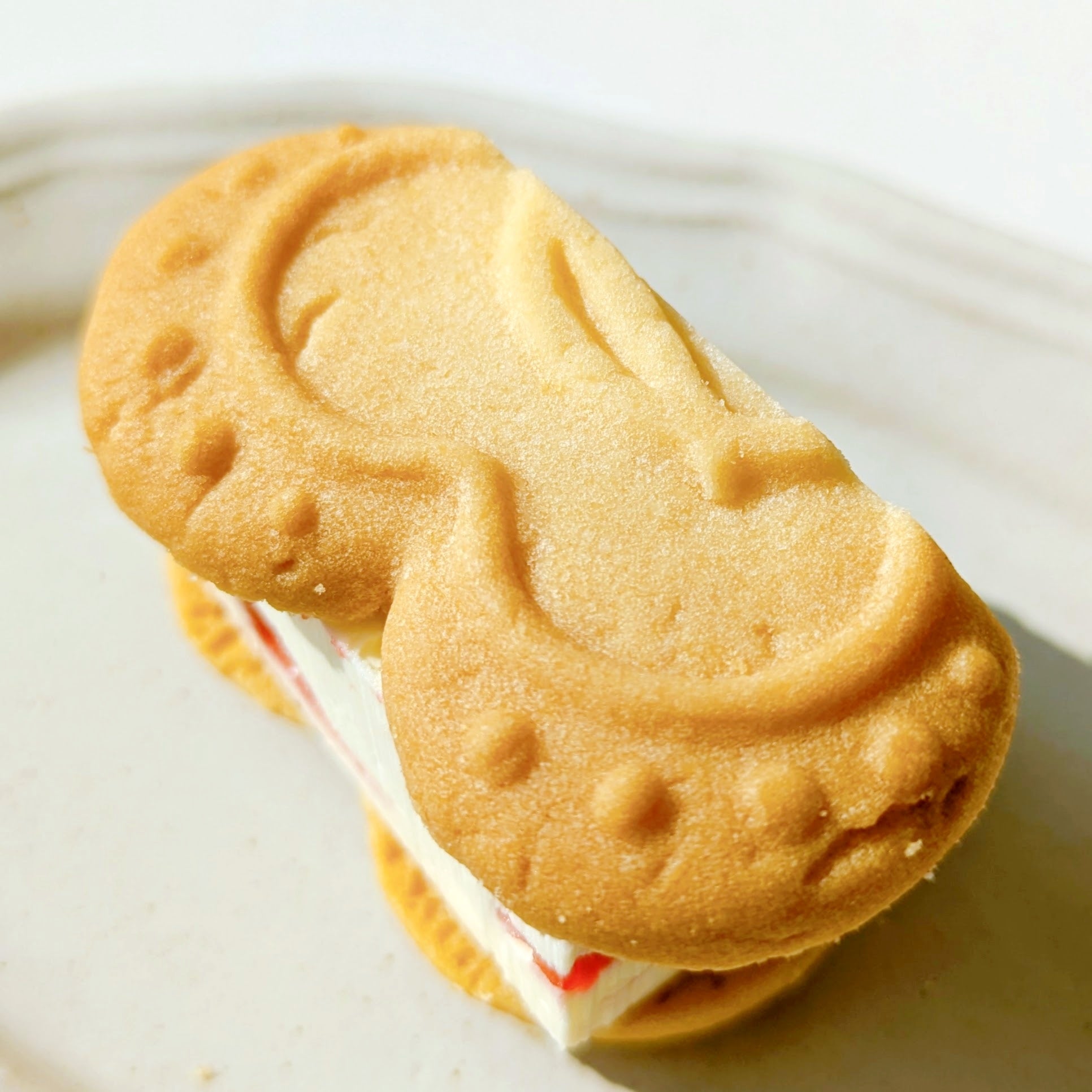 VERY RUBY CUT（ベリールビーカット）「いちごバターサンド」ホイップバタークリームを挟んだクッキーサンドが白い皿に乗っています。