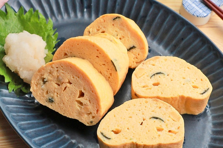 お皿に盛られた厚焼き卵が5切れ。大根おろしと葉が添えられている。