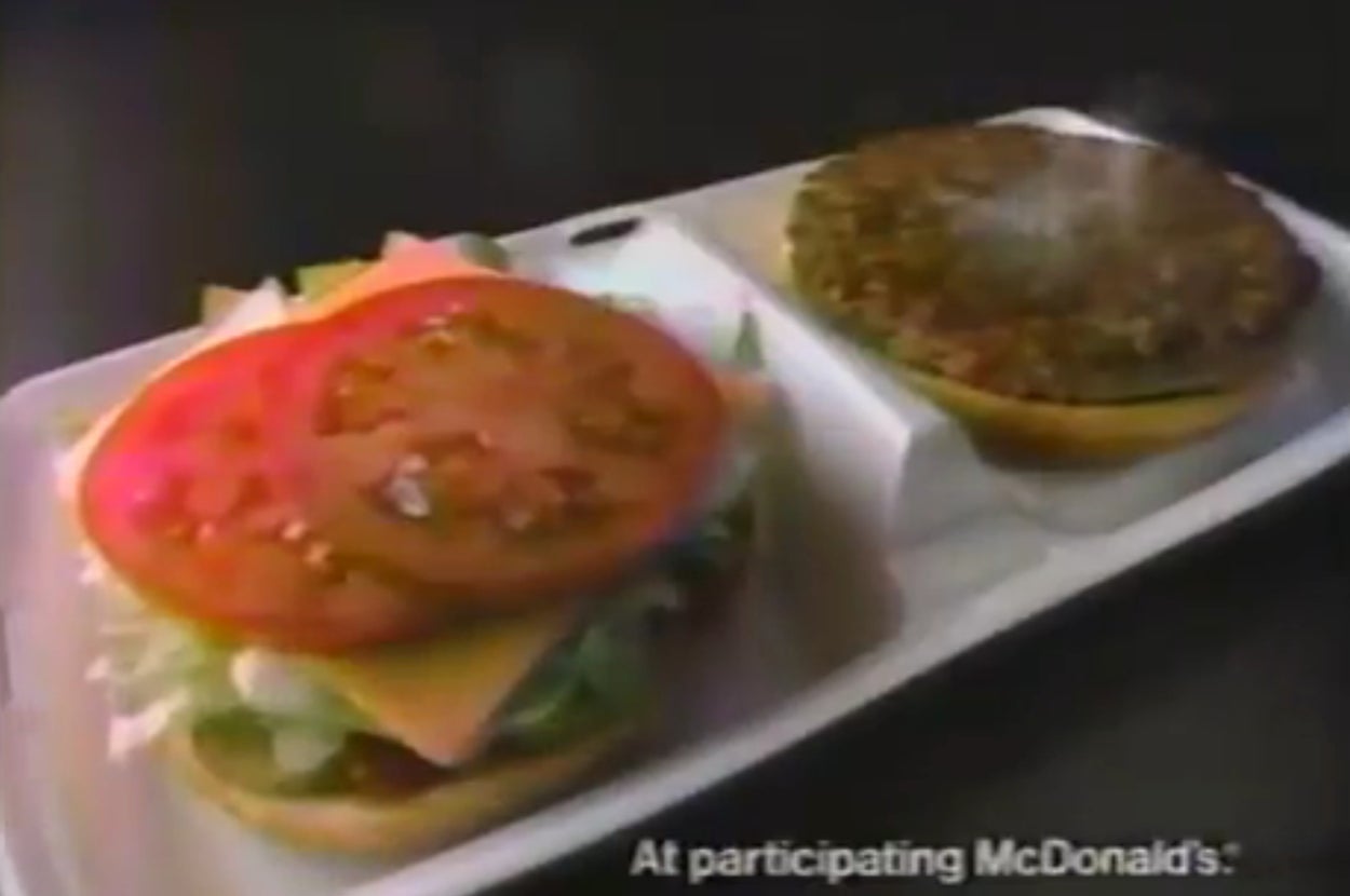 Open McDonald's burger showing lettuce, cheese, and tomato on one half, and a beef patty on the other, with steam rising from the patty