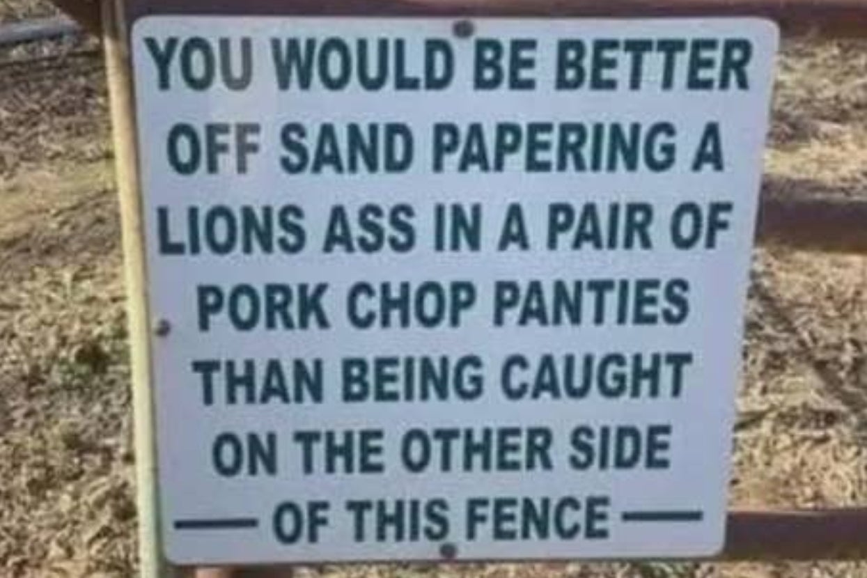 Humorous sign warns against trespassing with an exaggerated metaphor about danger involving a lion and pork chop panties