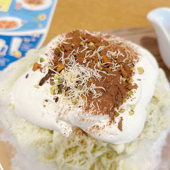 ココスの「純氷ふわふわかき氷 ドバイチョコ」トッピングのクリームやナッツのクローズアップ。