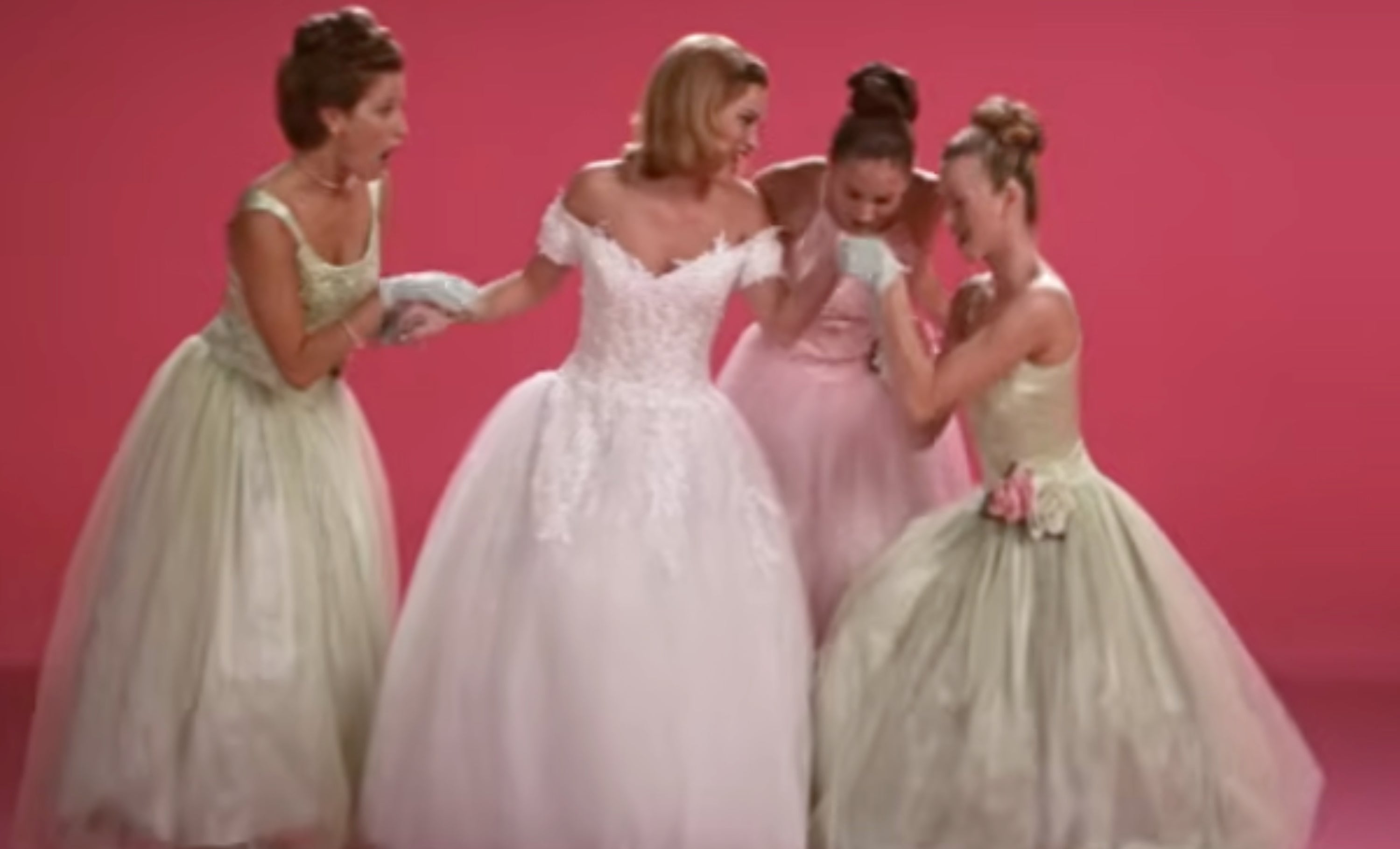 A bride successful  an off-shoulder lace wedding formal  poses happily, surrounded by bridesmaids successful  motion, holding bouquets