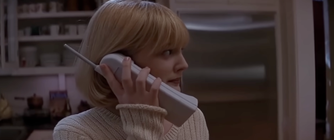 Drew Barrymore successful  Scream with abbreviated  blond hairsbreadth  holds a cordless phone, wearing a sweater, successful  a room  setting