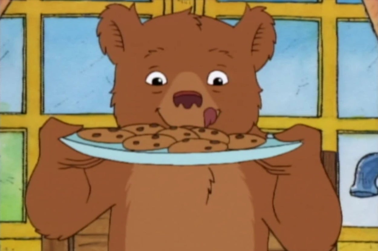 Cartoon bear holding a plate of cookies with a happy expression