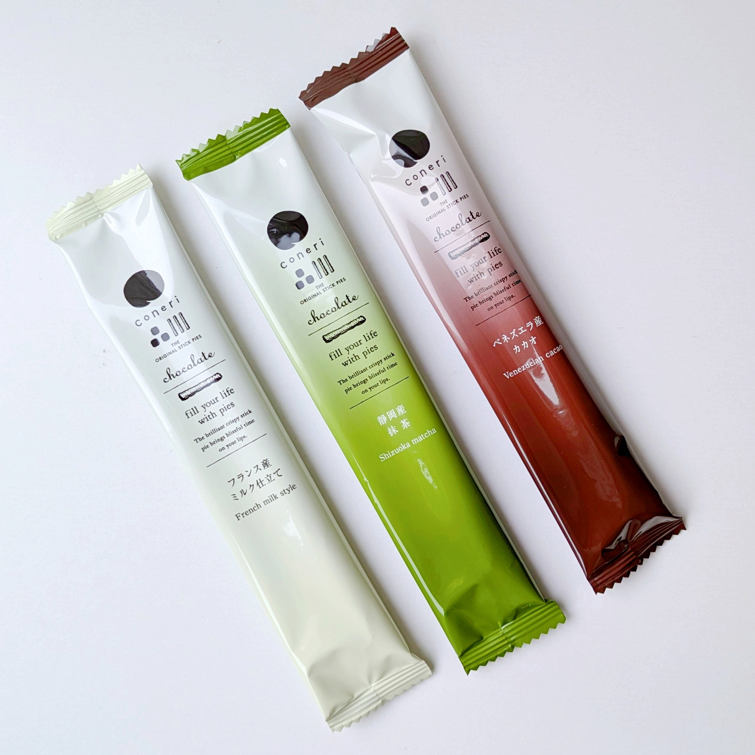 coneri（コネリ）「チョコレートスティックパイ」3本の細長いチョコレートスティックパイ。パッケージは白、緑、茶色で異なるフレーバーを示している。