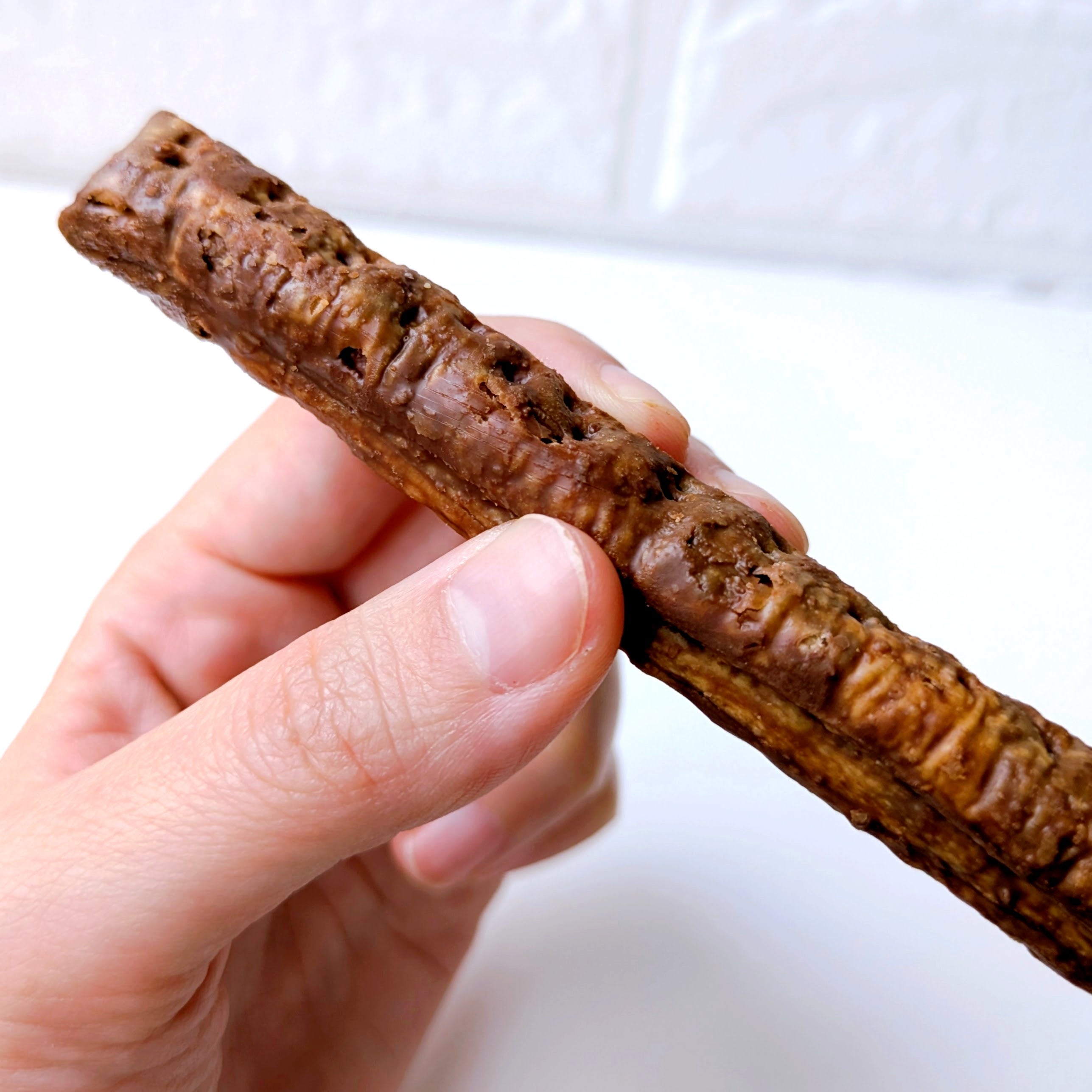 coneri（コネリ）「チョコレートスティックパイ」手に持たれたチョコレートスティックパイ。