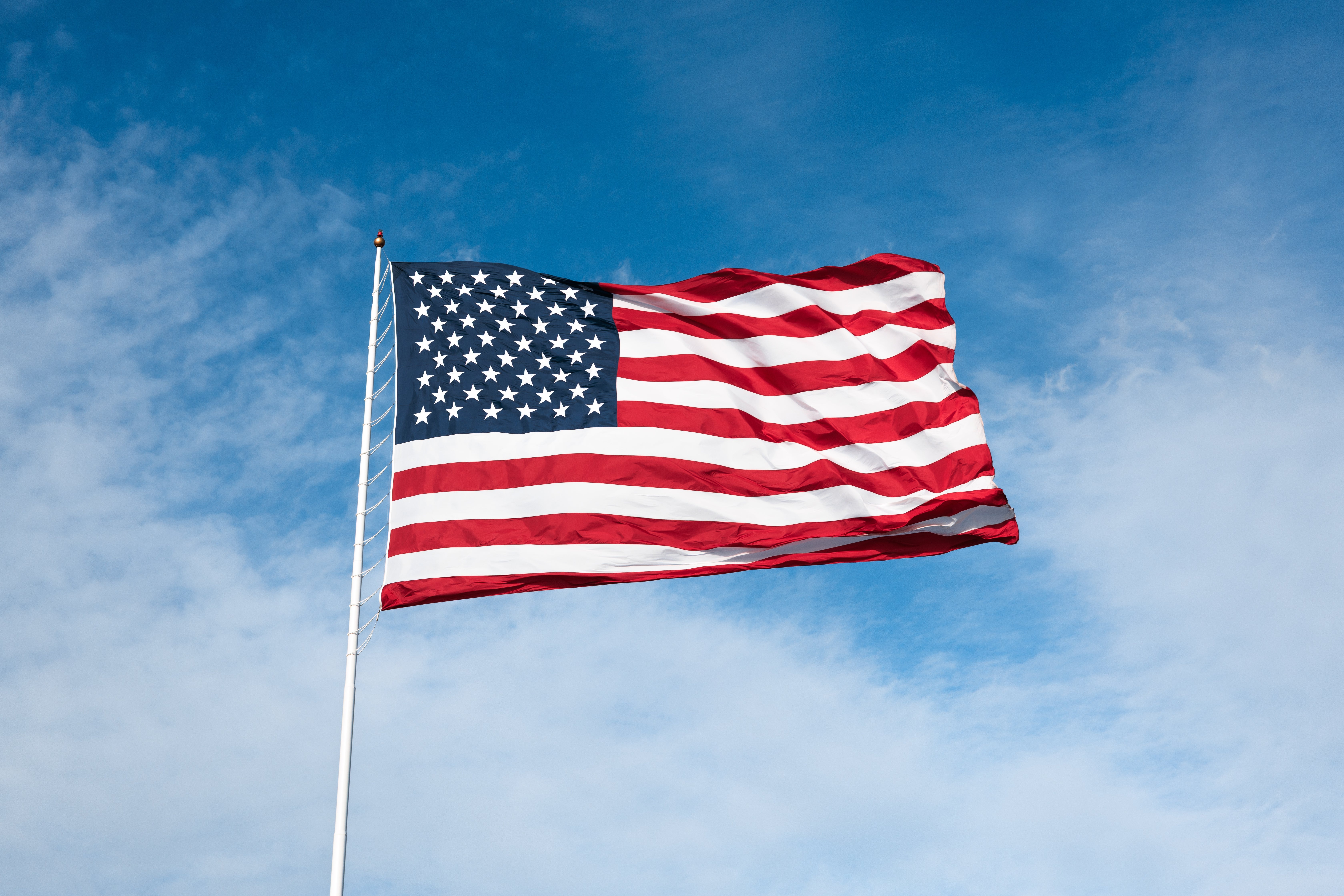 The representation shows the American emblem waving against a partially cloudy bluish sky