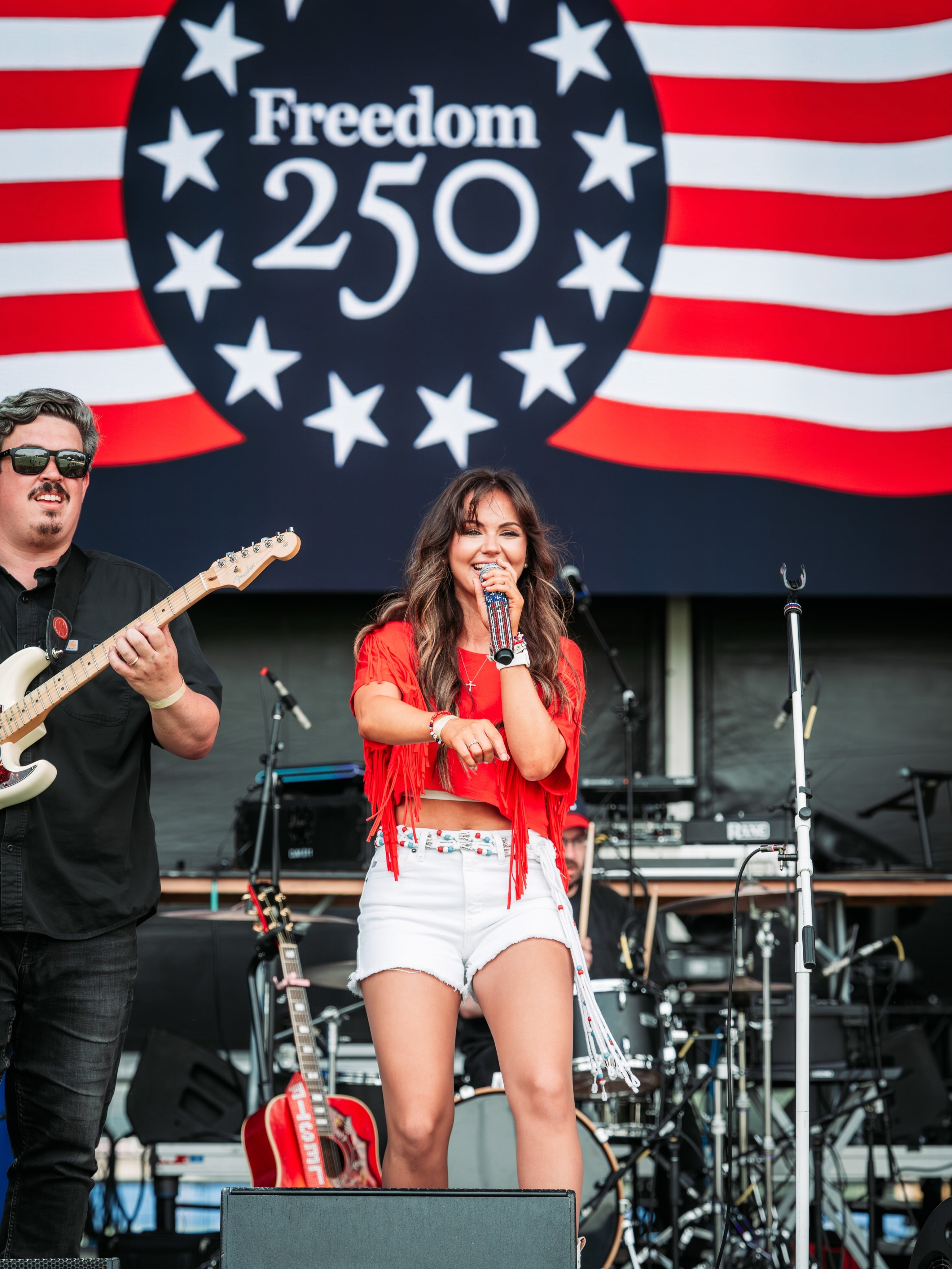 Celeste performing connected  stage, with an electrical  guitarist beside her