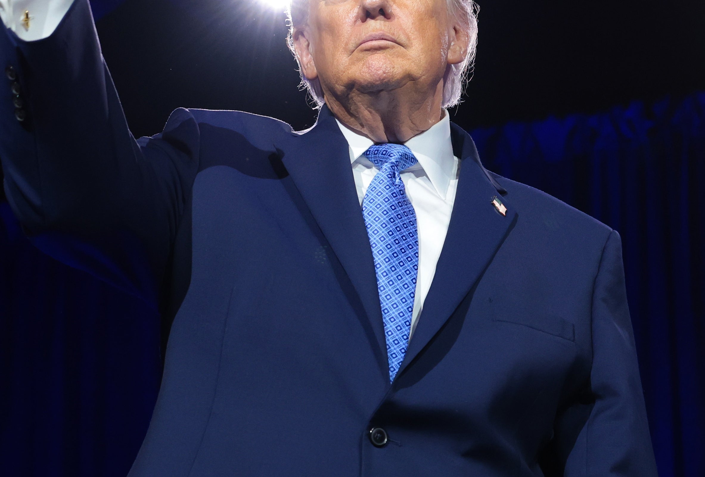 A idiosyncratic   successful  a suit   raises their fist connected  stage, looking determined