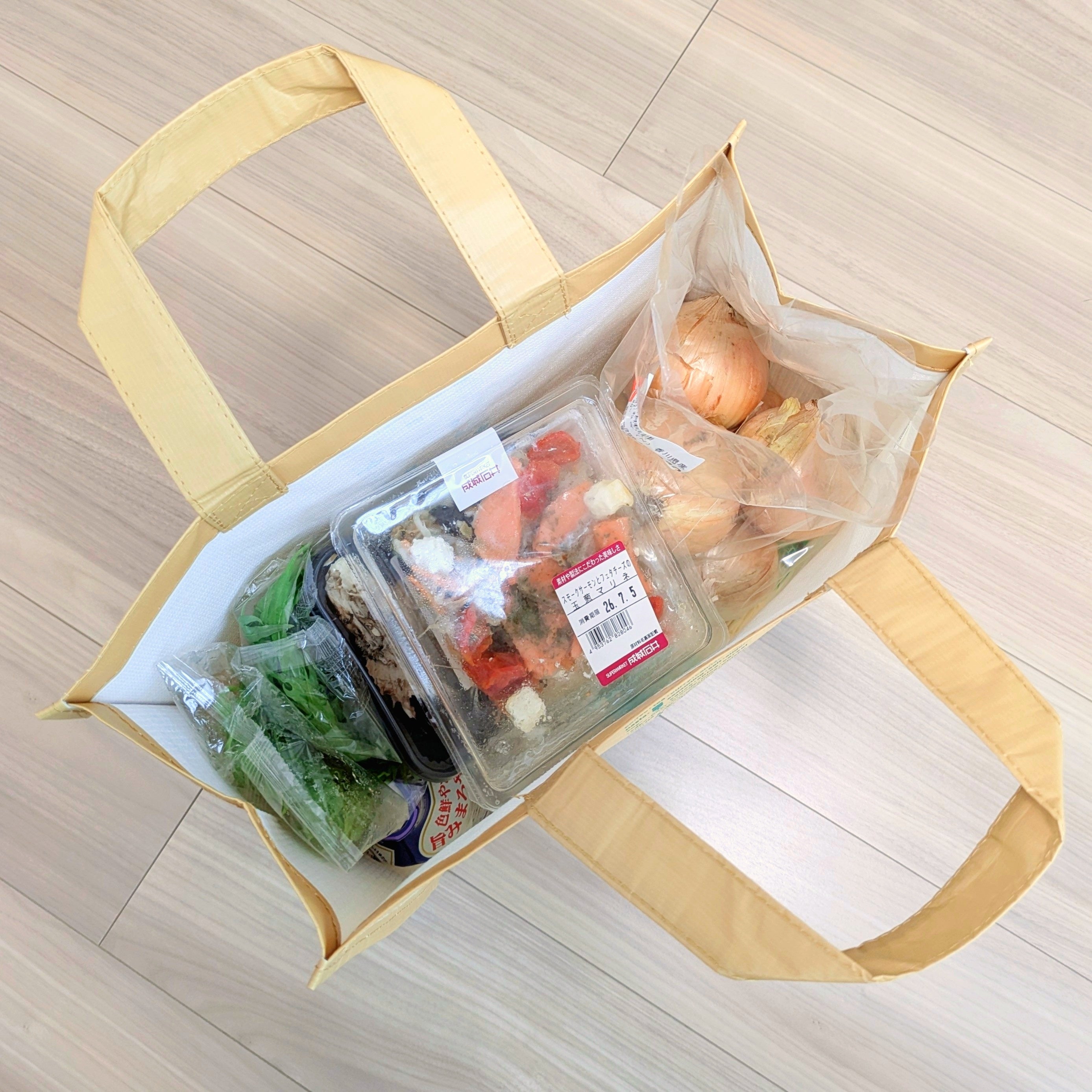成城石井「リサイクルエコバッグ」買い物袋に玉ねぎ、サラダ、野菜パックが入っている様子。