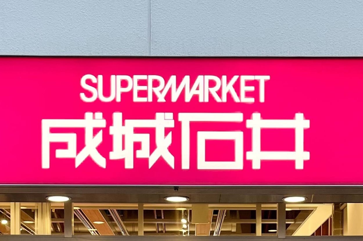 スーパーマーケットの外観。看板に「スーパー成城石井」と書かれている。店舗の入り口が見える。