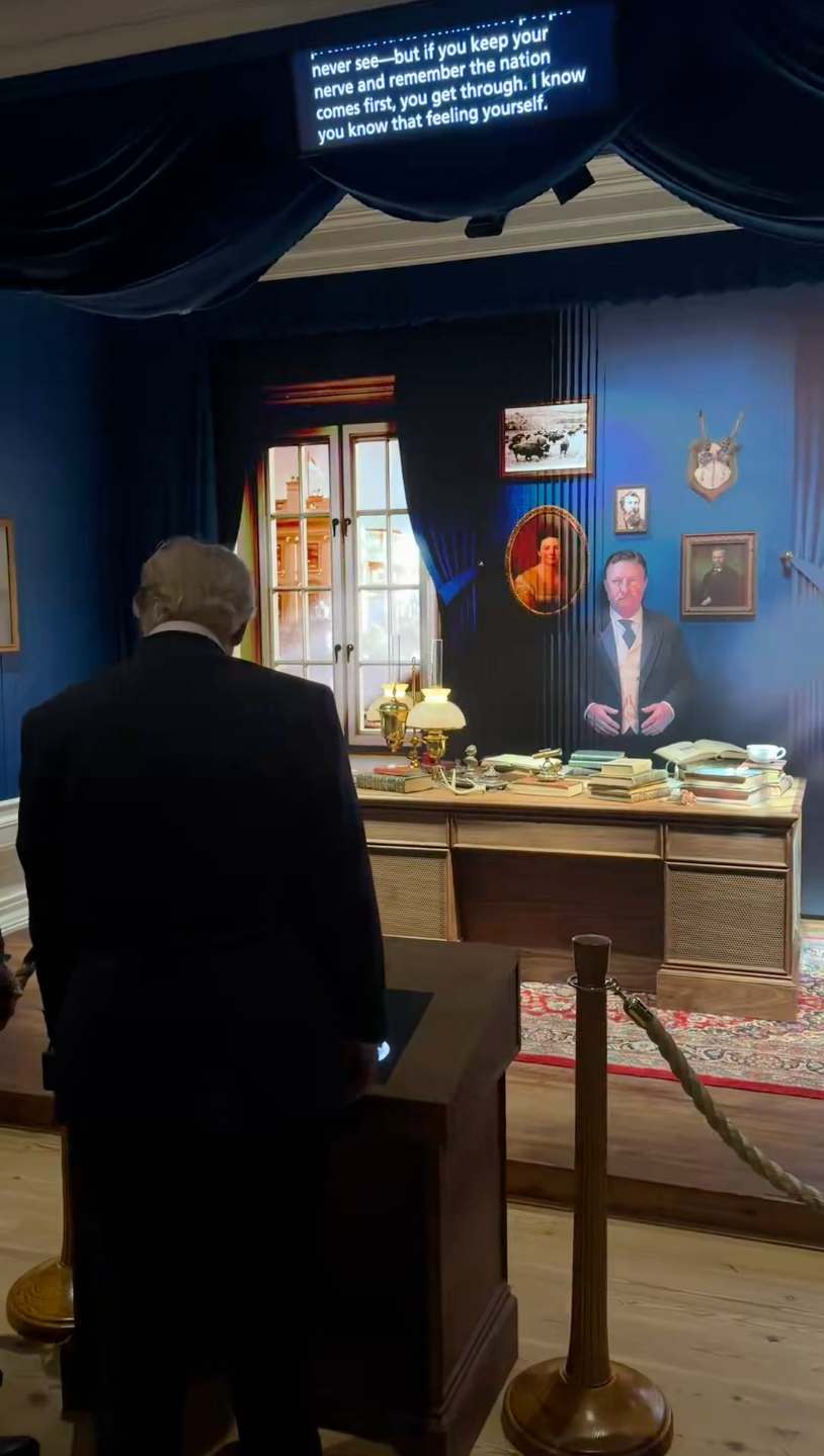 Donald Trump viewing an grounds featuring a decorated table with assorted humanities artifacts and portraits, nether a show surface with captioned text