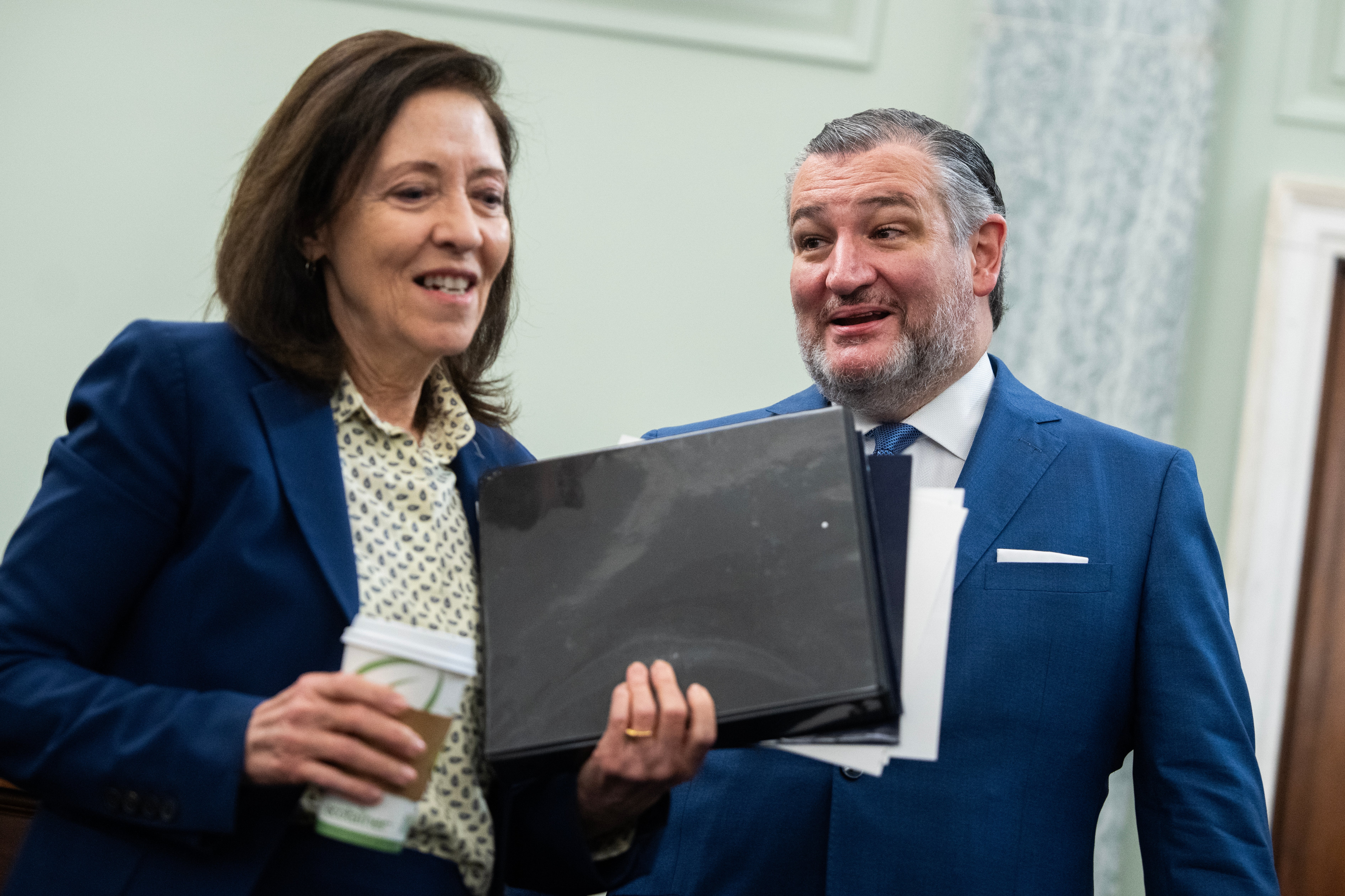 Two radical   successful  suits are engaged successful  conversation, holding documents and a java  cup