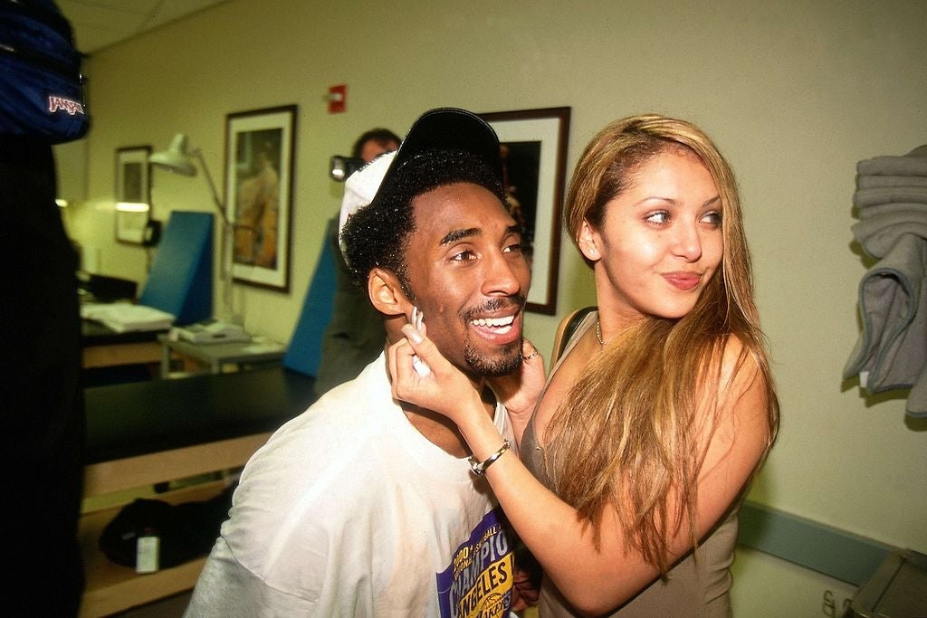 Kobe Bryant and Vanessa Lang next to each other smiling while Vanessa grabs his face
