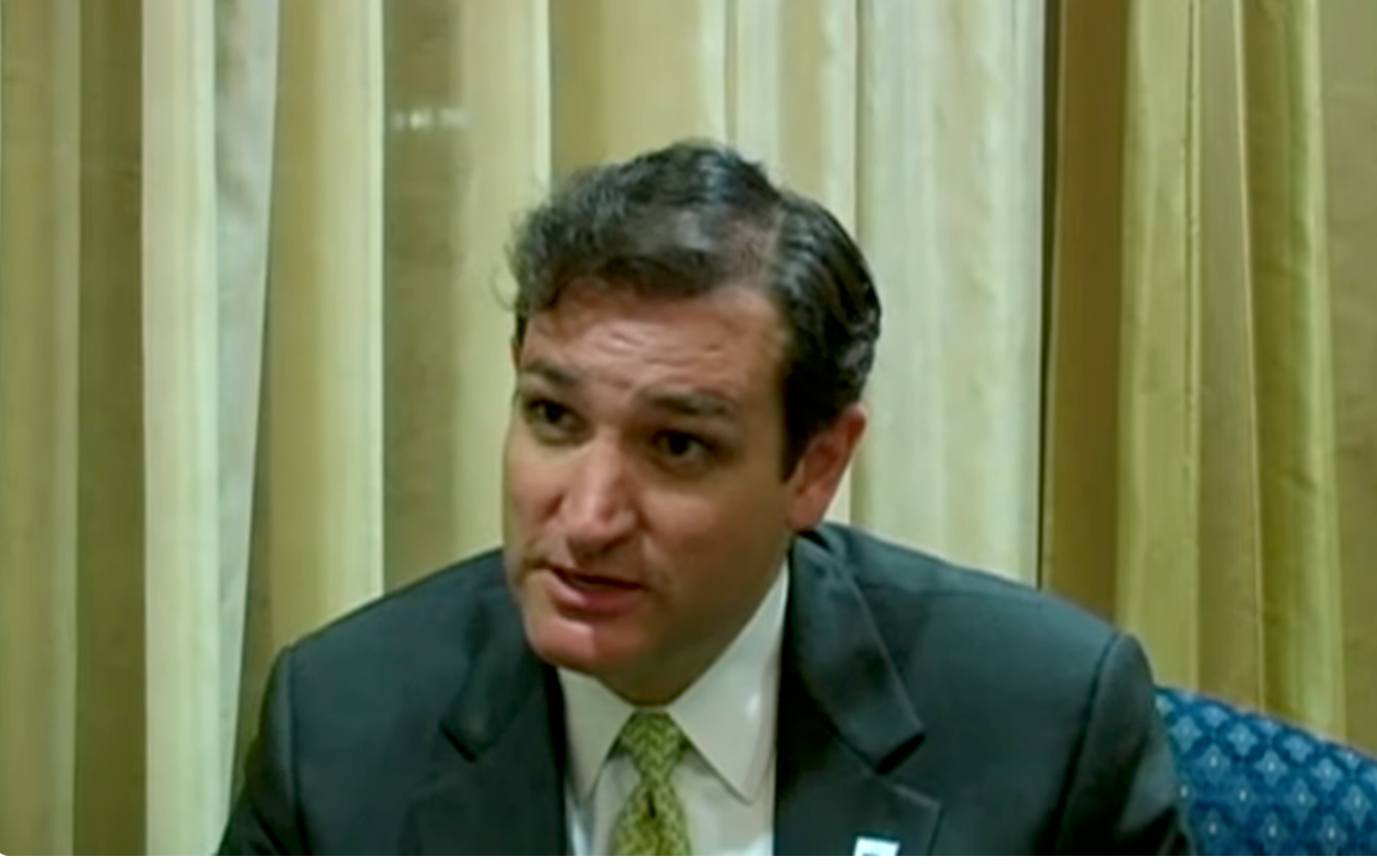 A idiosyncratic successful a suit and necktie is seated successful an interrogation setting, looking attentive