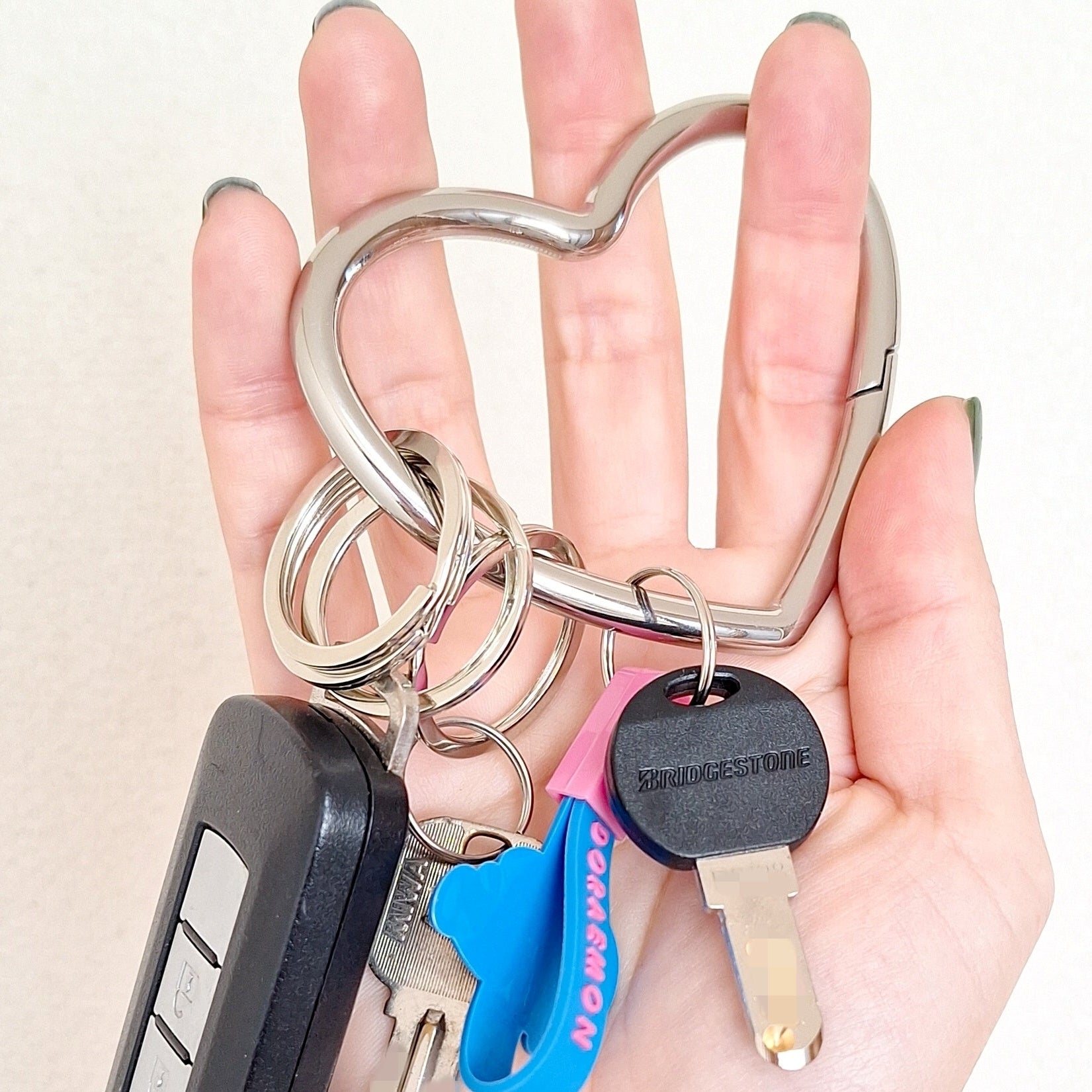 ダイソーの「メタリックハートカラビナキーホルダー」複数の鍵と車のリモコンがついている様子。