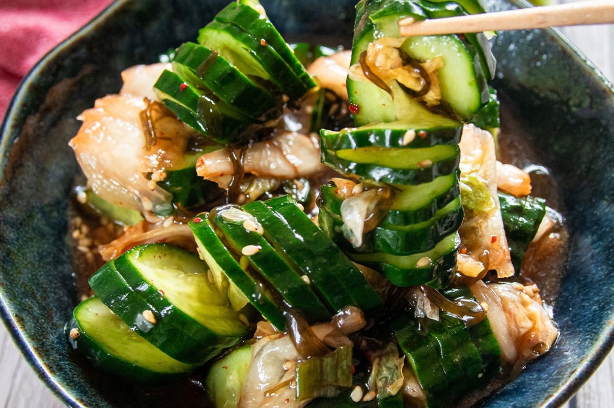 皿に盛られたきゅうりとキムチの和え物。ごまと調味料がかかっている。