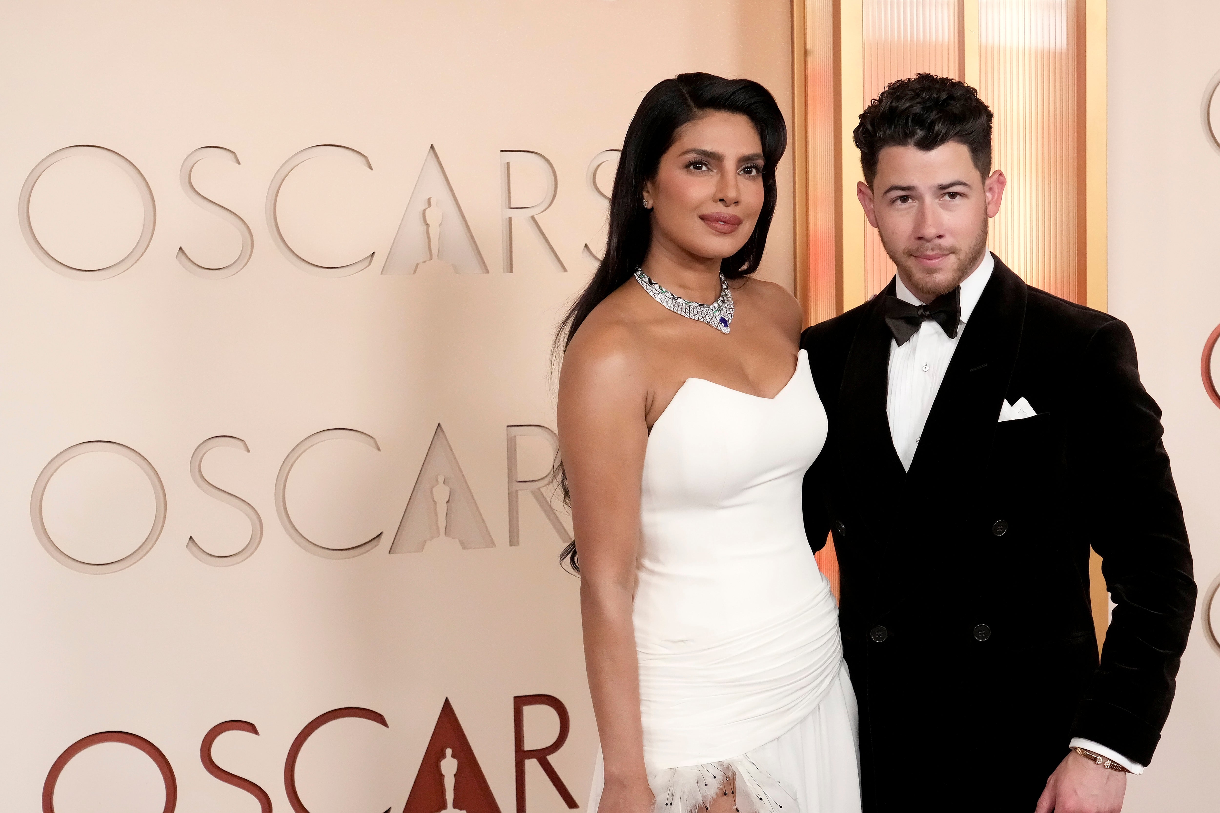 I don't know who these people are, but they are posing on a red carpet. The woman is in a strapless gown; the man is in a tuxedo