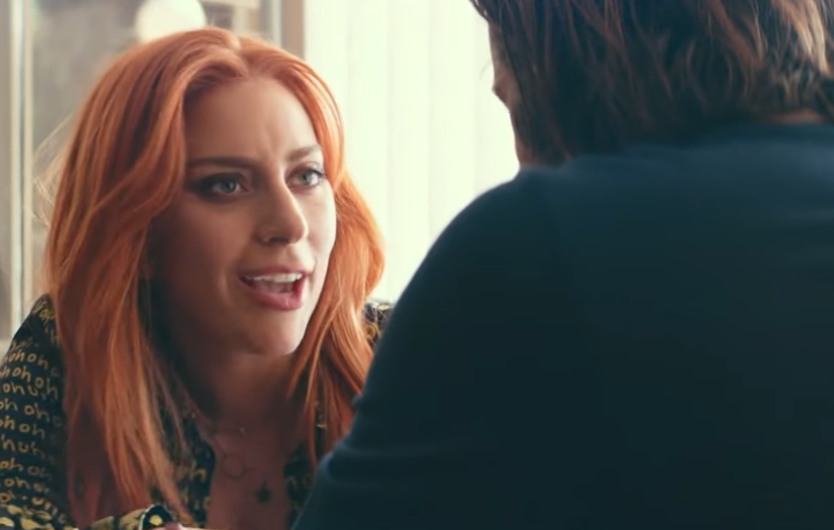 Two people having a close, intimate conversation; the woman has a patterned outfit