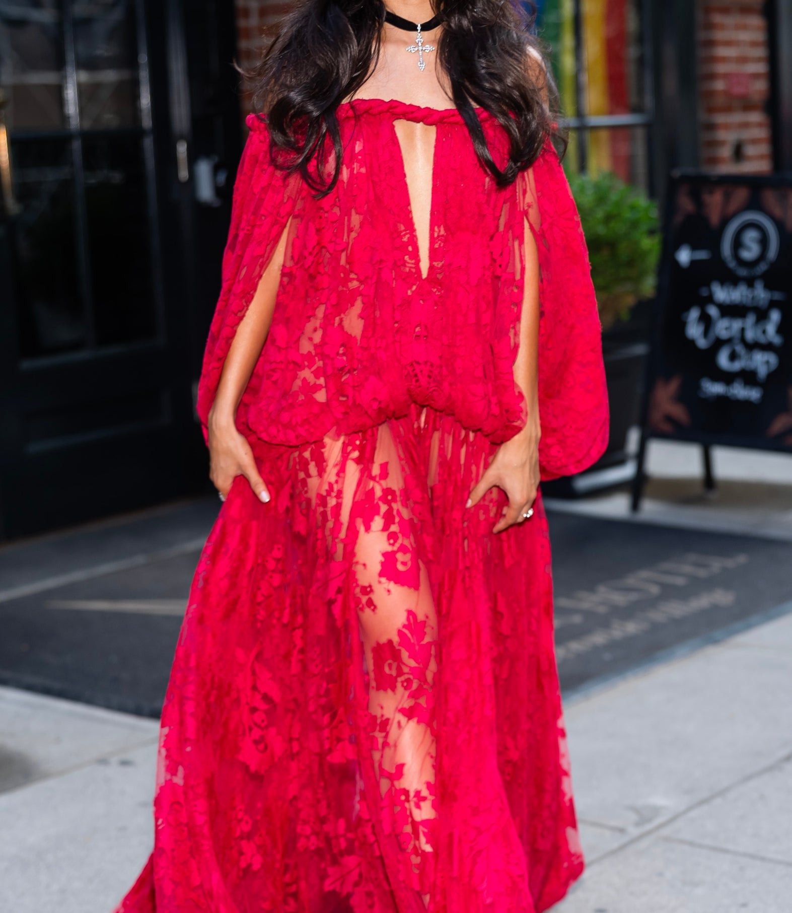 A idiosyncratic   poses successful  a flowing lace gown with cape sleeves, walking connected  a street