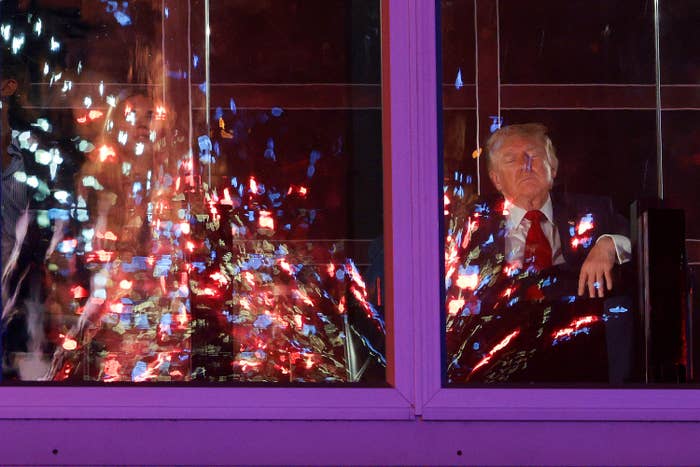 Person with eyes closed sitting inside, reflections of fireworks connected  model   glass