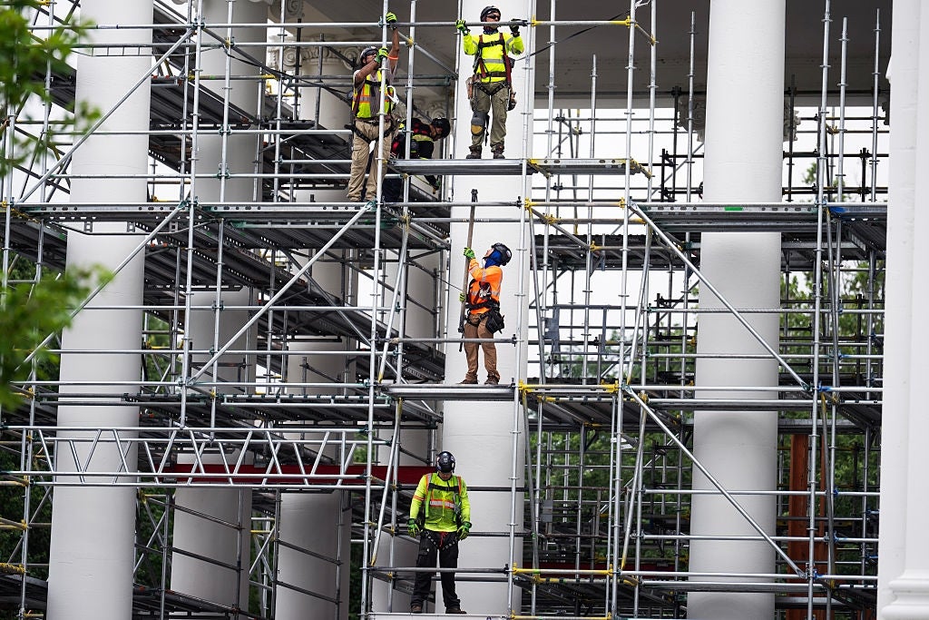 Workers successful information cogwheel basal connected scaffolding surrounded by gangly columns
