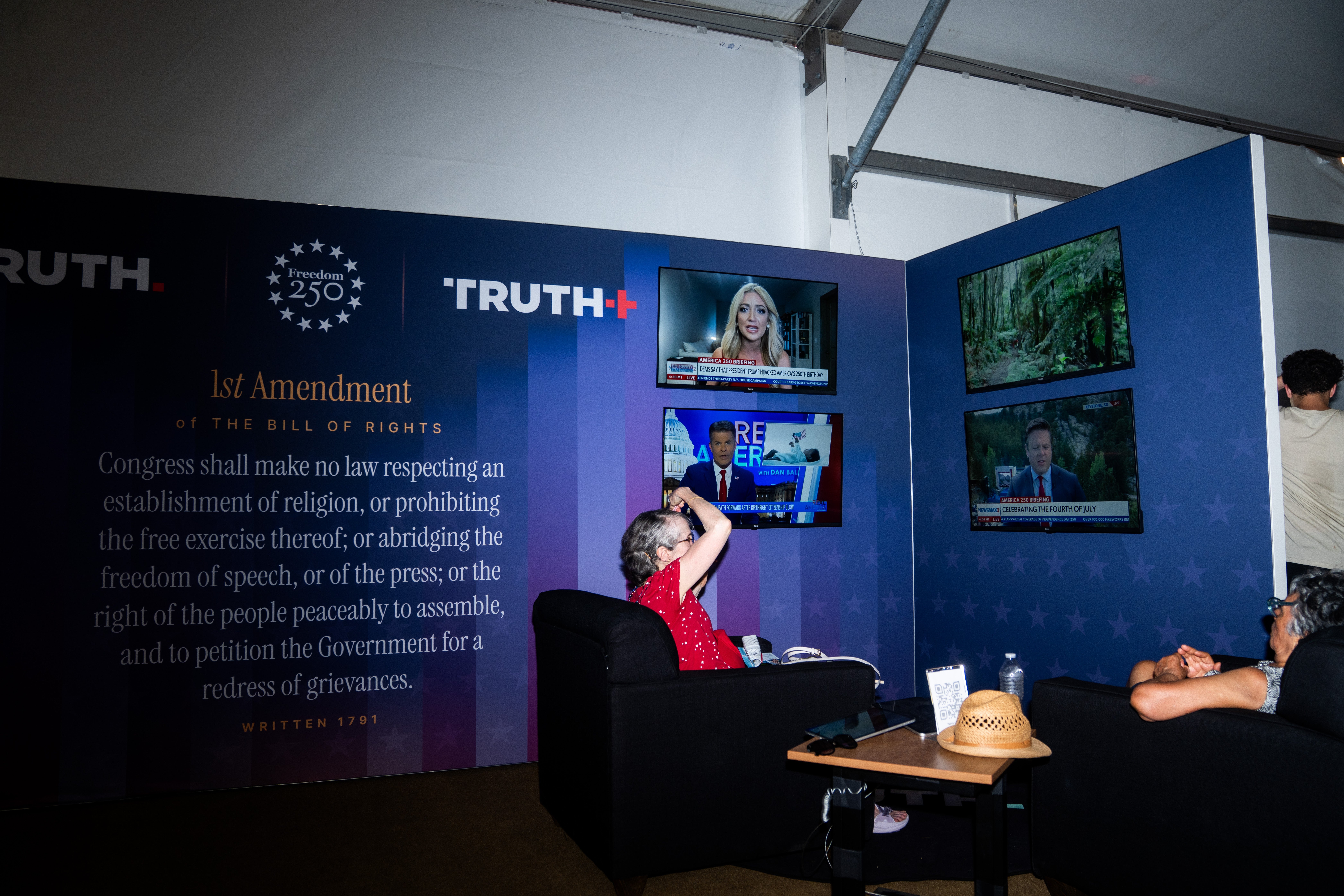 People watching quality connected aggregate screens astatine a media lawsuit with a ample partition displaying First Amendment substance successful the background