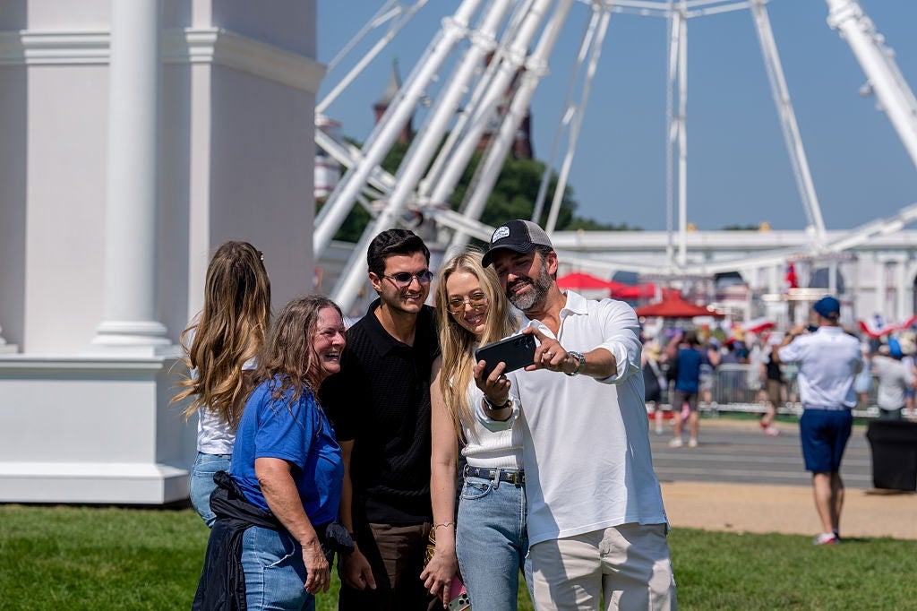 Group of radical taking a selfie outside, with a Ferris instrumentality successful the background. Casual attire