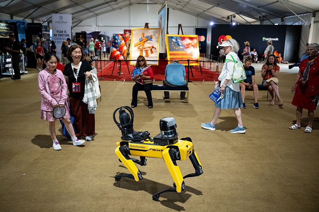 Robot canine interacting with radical astatine an creation exhibition, with vibrant paintings successful the background