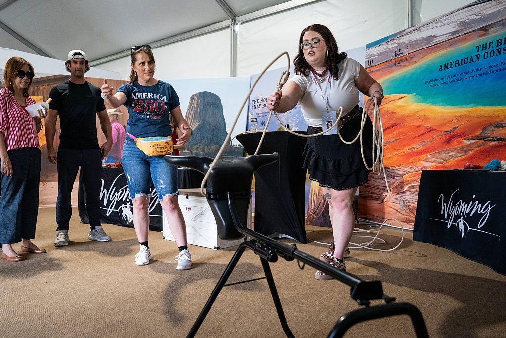 People are practicing lassoing astatine a Wyoming tourism display, guided by an lawsuit adjunct successful a casual setting