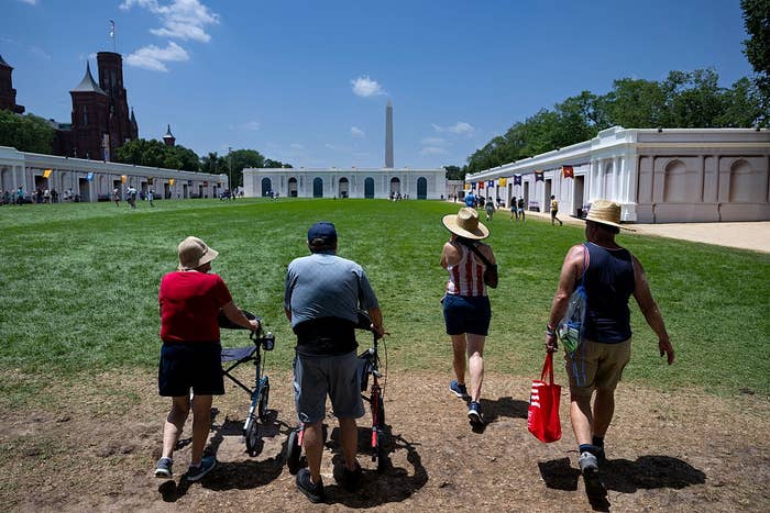 Four radical   locomotion  toward the Washington Monument connected  a sunny day, 2  utilizing walkers, wearing casual summertime  attire and hats