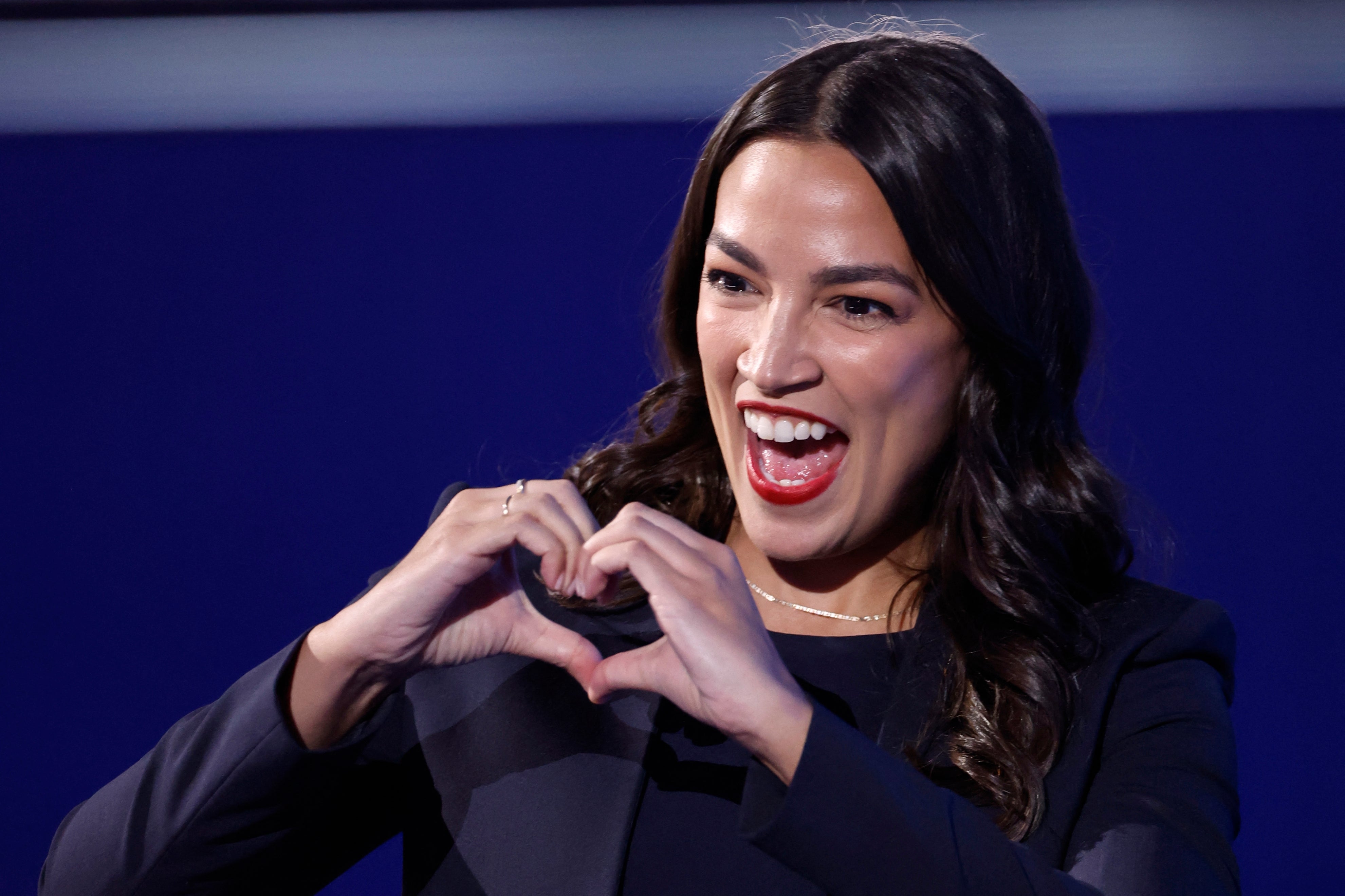Person successful a acheronian outfit making a bosom signifier with hands, smiling and showing enthusiasm