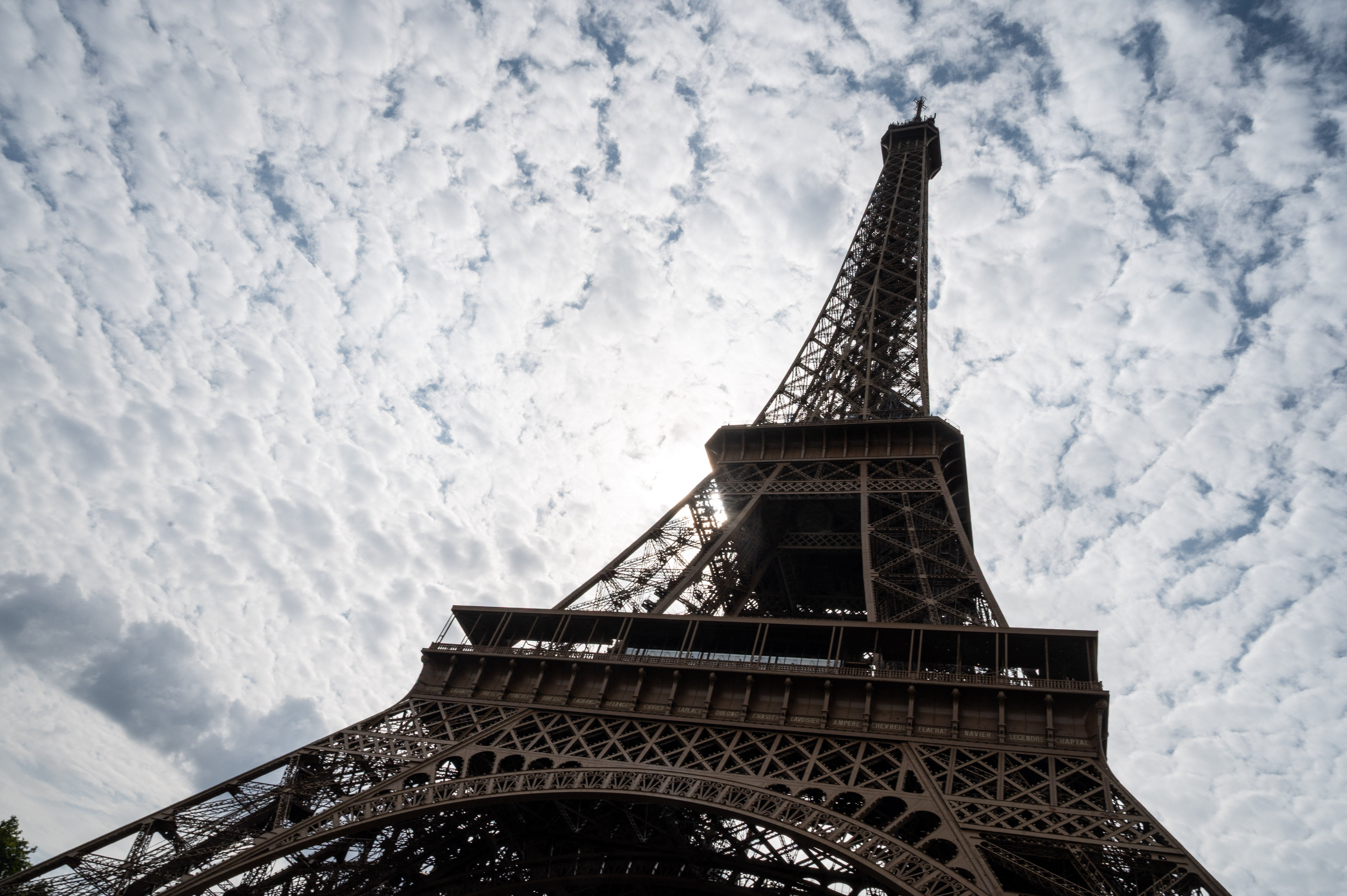 Low-angle presumption    of the Eiffel Tower against a entity  filled with scattered clouds