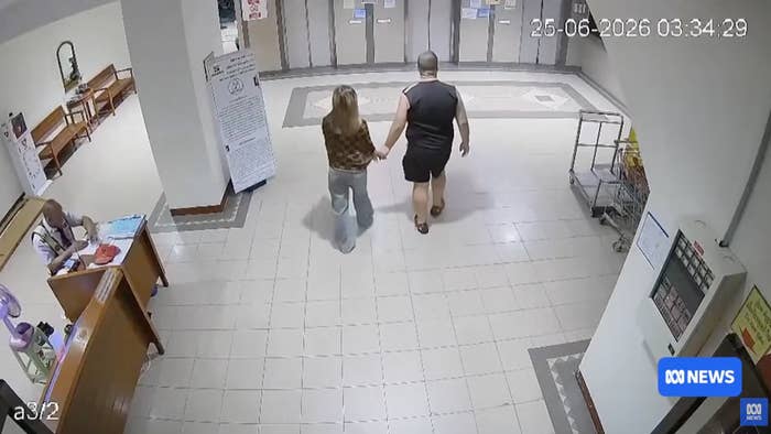 Two radical   locomotion  down   a hallway unneurotic  with cameras capturing their movements
