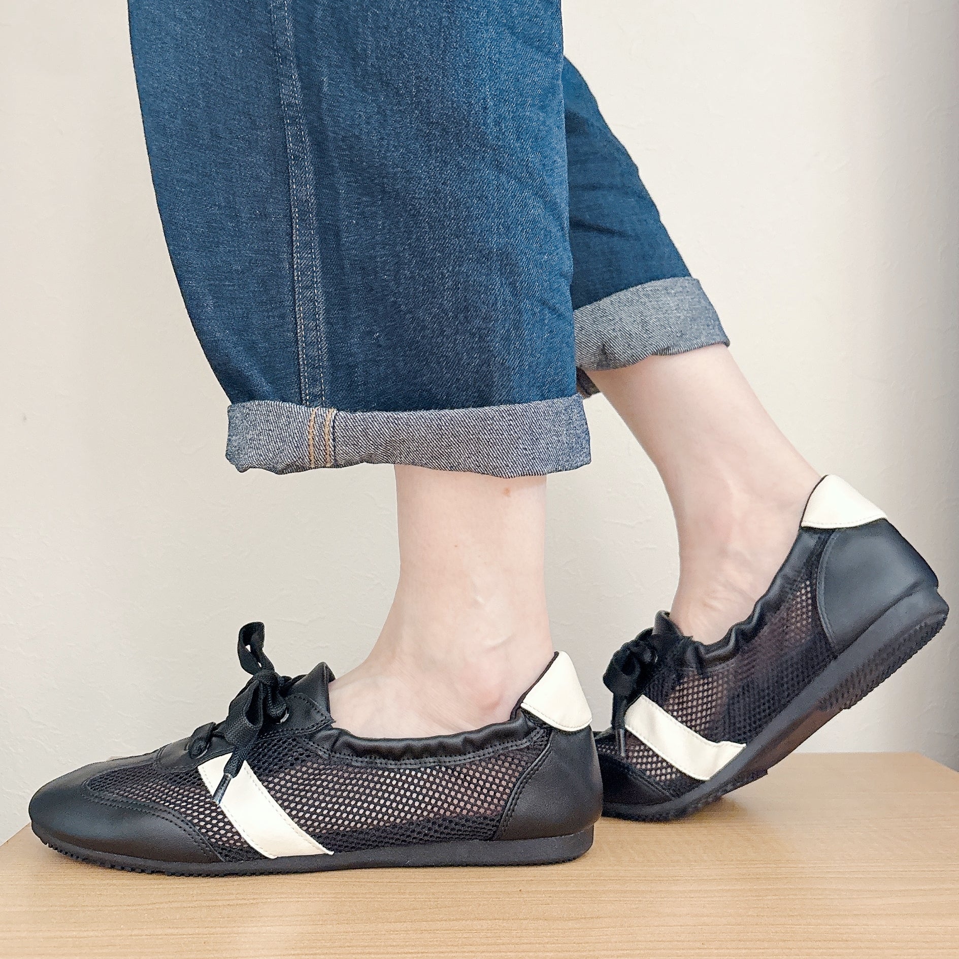 GU（ジーユー）の「メッシュギャザーバレエスニーカー」デニムの裾を折った人物が履いている。