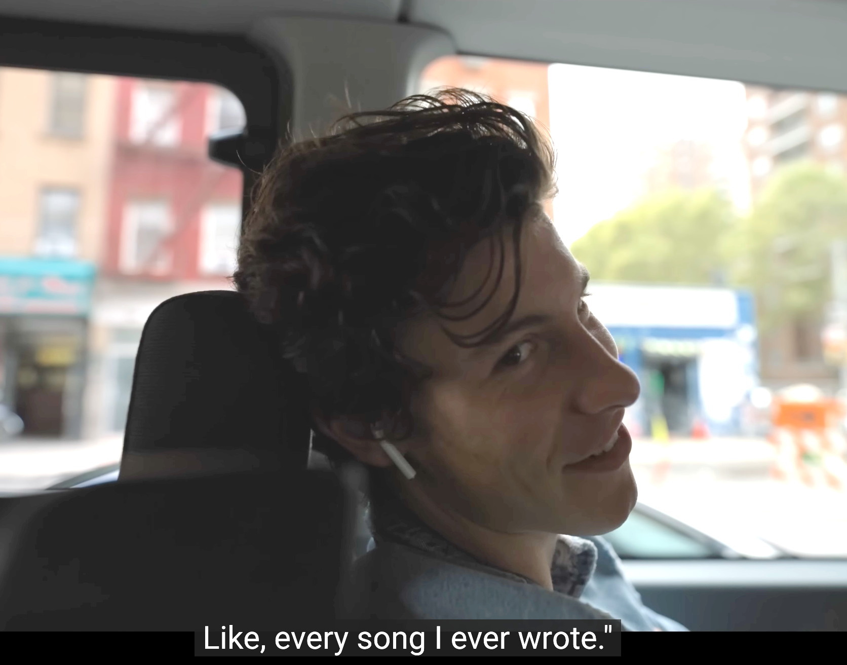 Person successful a car spot wearing earbuds, looking backmost with the caption "Like, each opus I ever wrote."