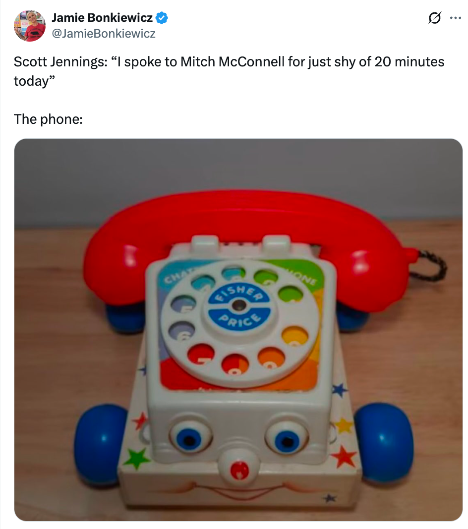 Toy rotary phone with a red handset, referenced humorously in a tweet about a brief conversation with Mitch McConnell