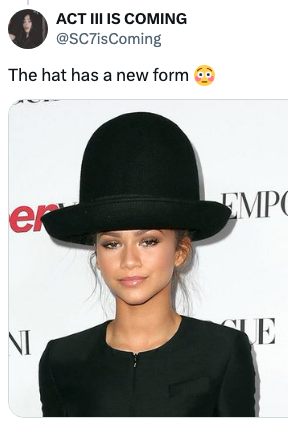 Celebrity on red carpet wearing a unique large hat with sleek black outfit