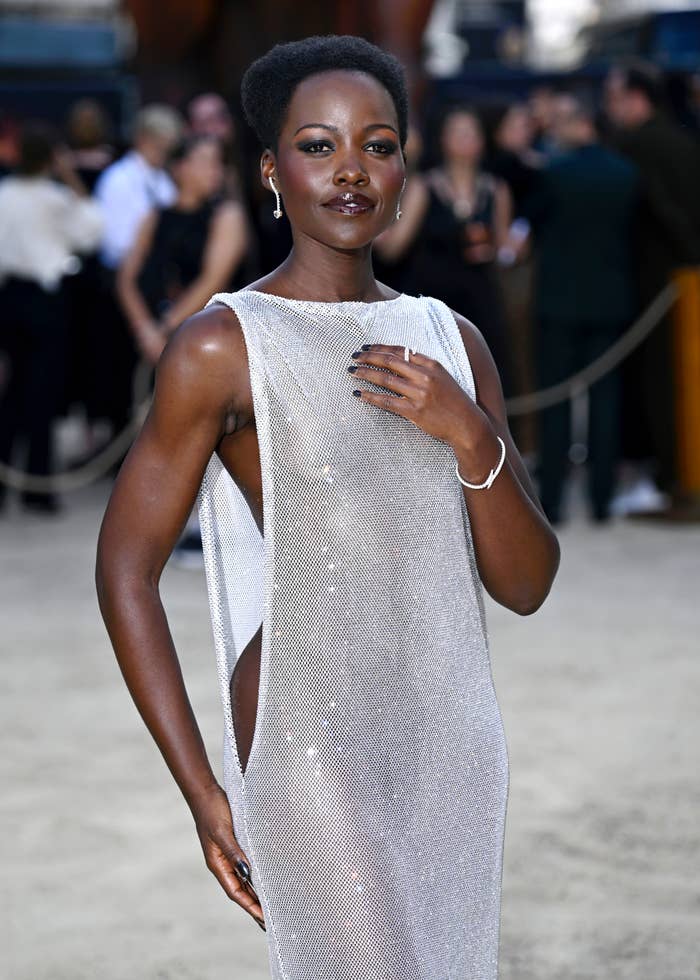 Lupita Nyong'o successful  a glamorous see-through gown poses confidently astatine  an event, accentuating modern   elegance